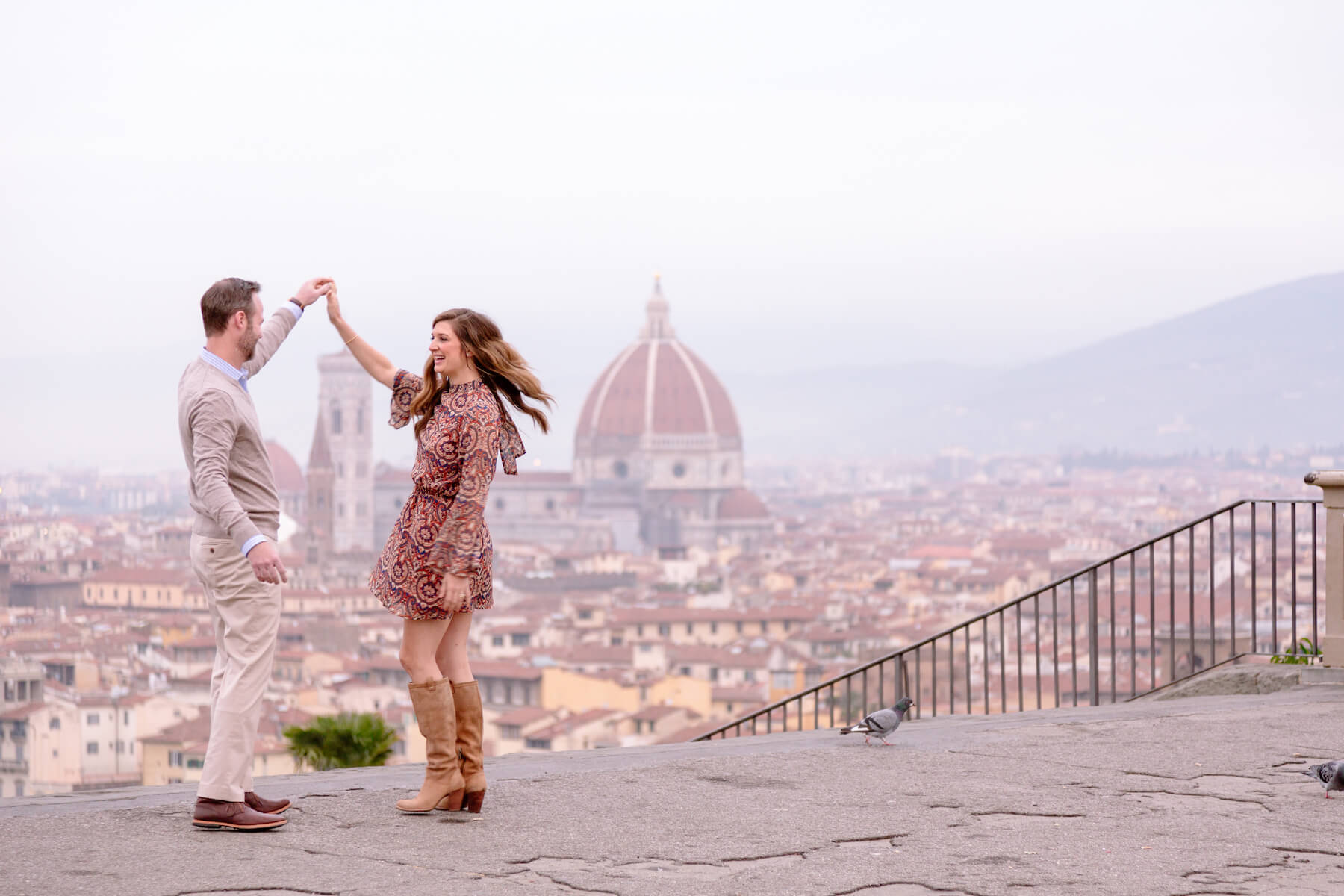Couple dancing on a lookout point, overlooking the city of Florence, Italy
