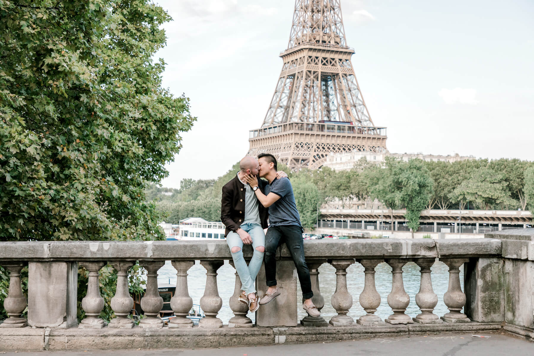 A couple kissing each other in front of the Eiffel Tower in Paris France