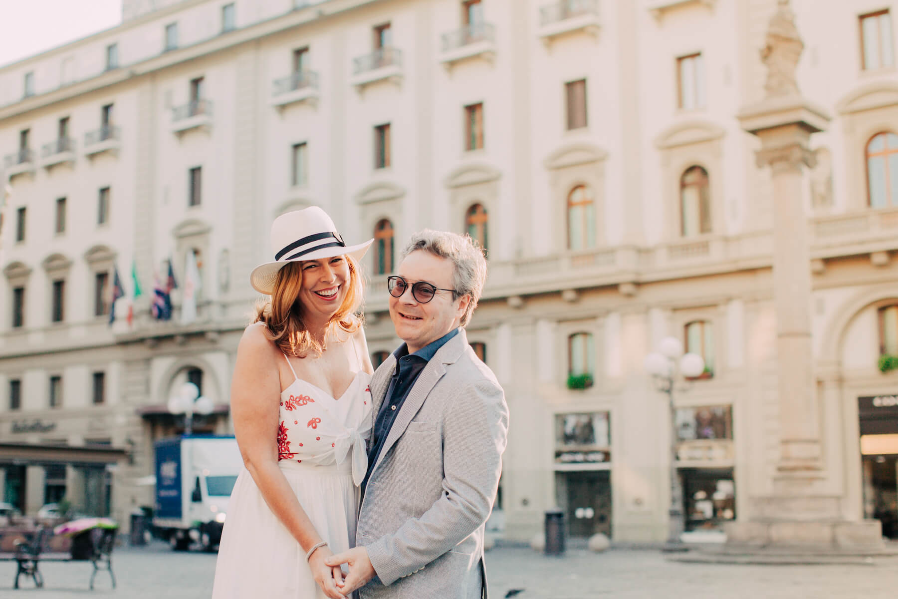 couple in a square holding hands and laughing in Florence, Italy