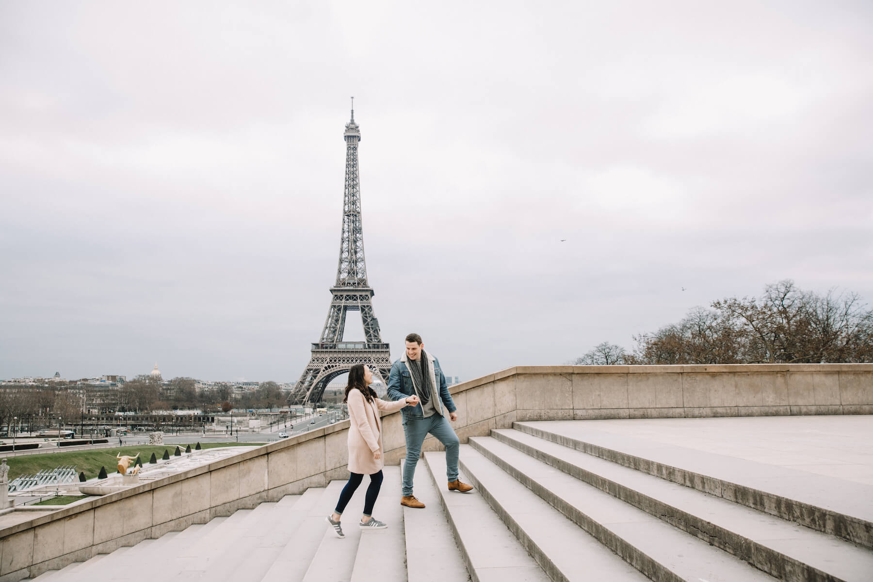 A man walking up stairs with a woman near the Eiffel tower in Paris, France