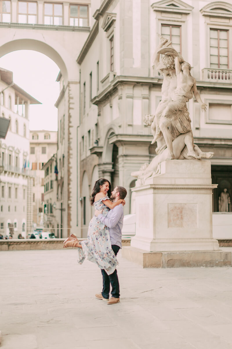 couple + woman is being lifted by the man in front of the Duomo Florence, Italy