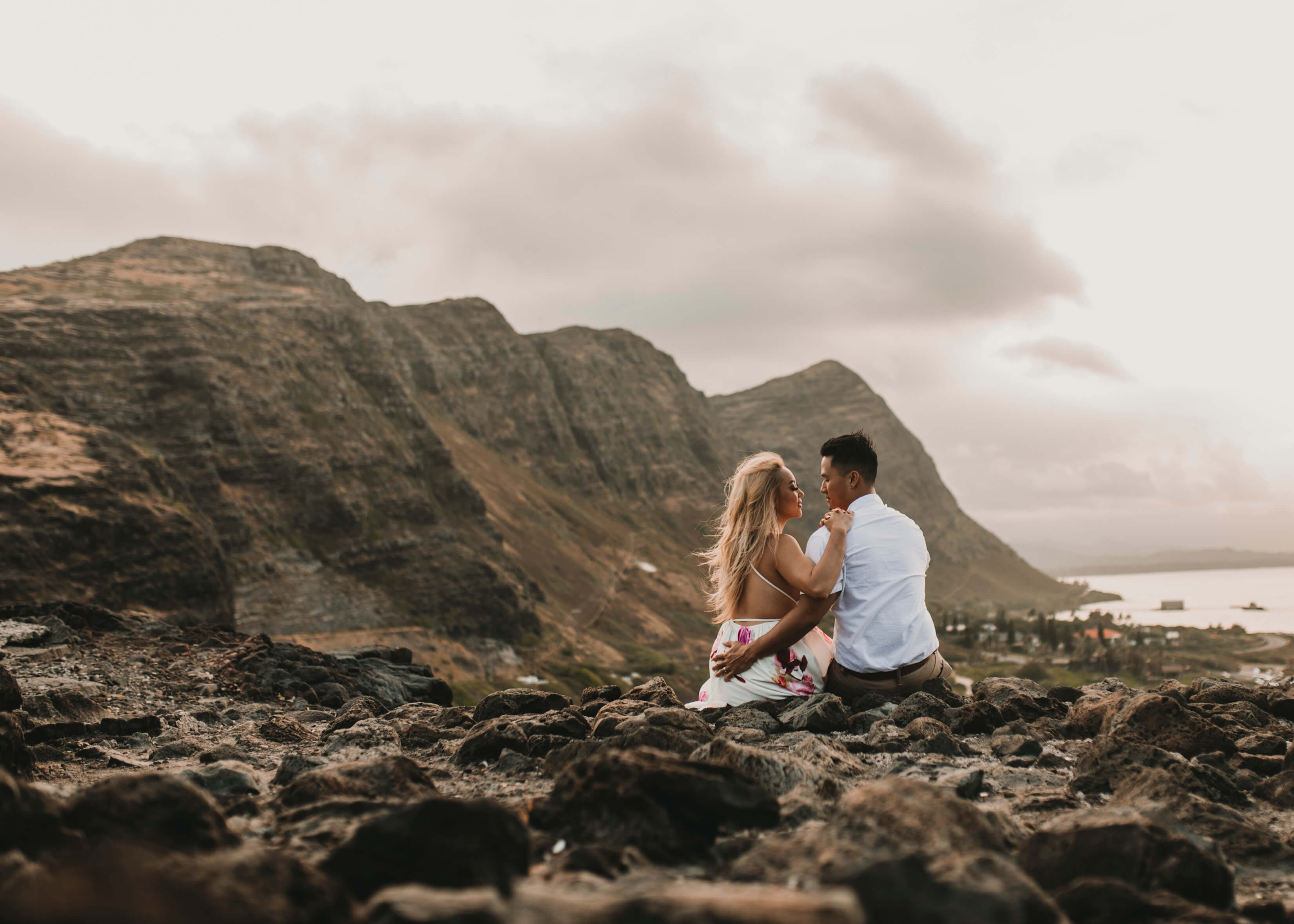 A couple sitting on a rocky ledge with looking at the views in Honolulu, Hawaii