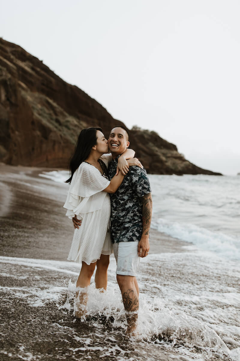 couple laughing on the beach in Maui, Hawaii