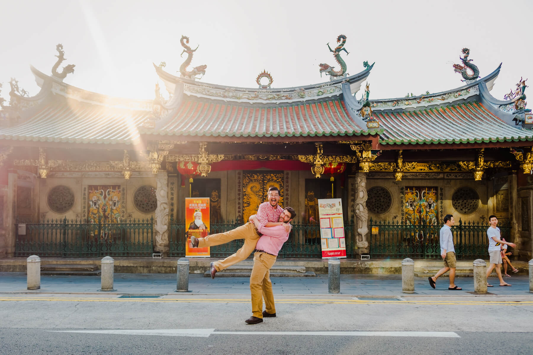 couple in front of a temple, one person is lifting the other person and both are laughing in Singapore, Singapore 