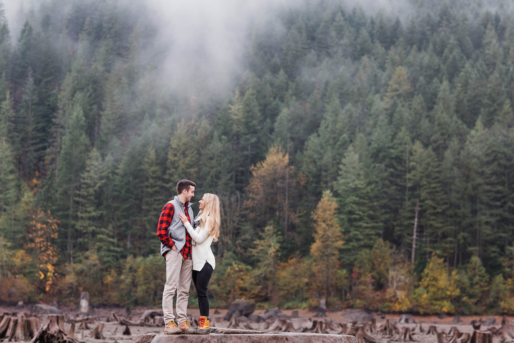 couple embracing at Rattle snake lake, it's foggy and raining in Seattle, Washington
