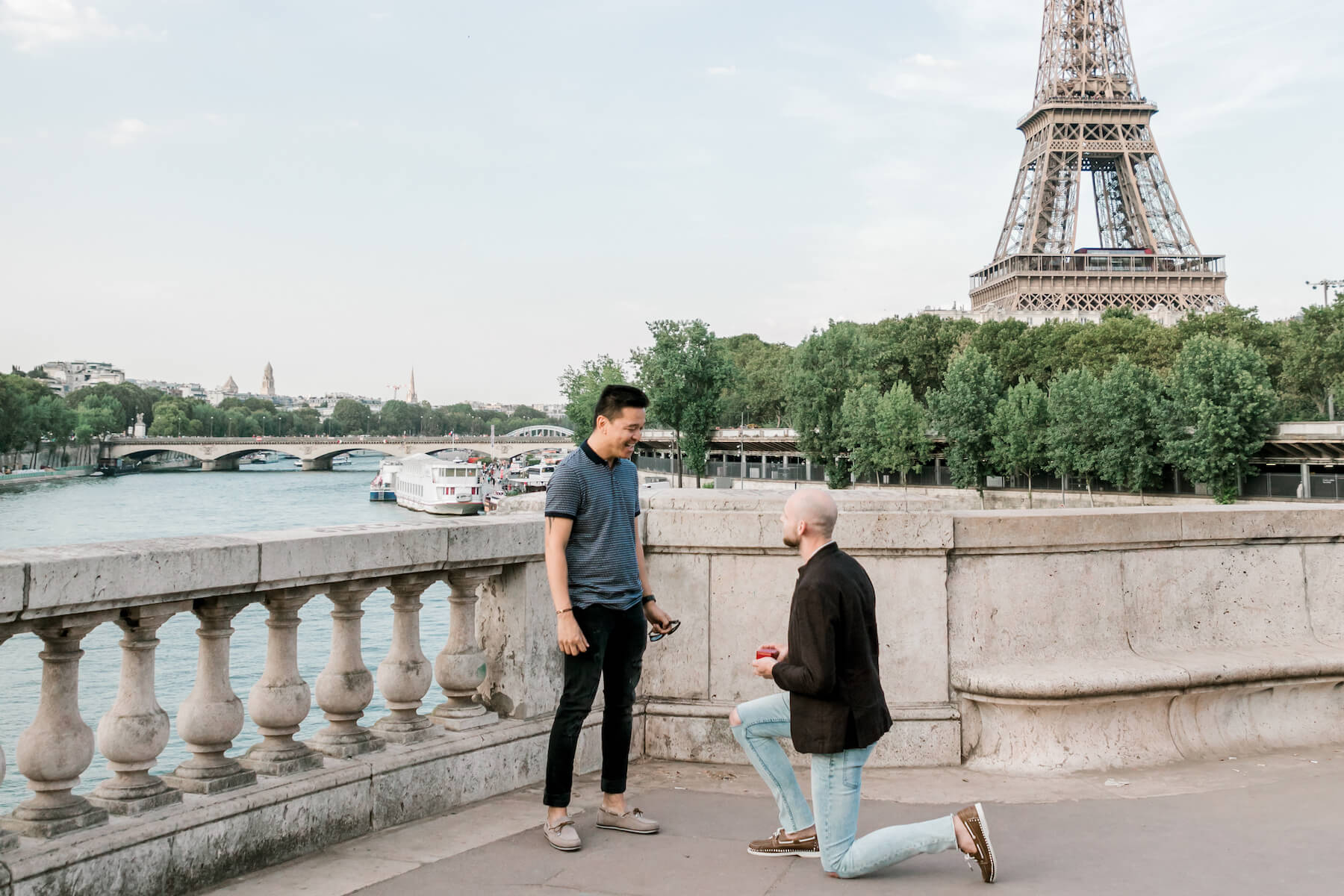 A man proposes on one knee in front of the Eiffel tower in Paris, France
