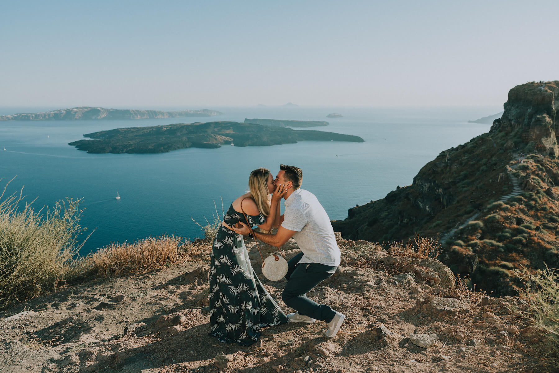 couple in Santorini, the man is proposing and the woman is surprised in Santorini, Greece