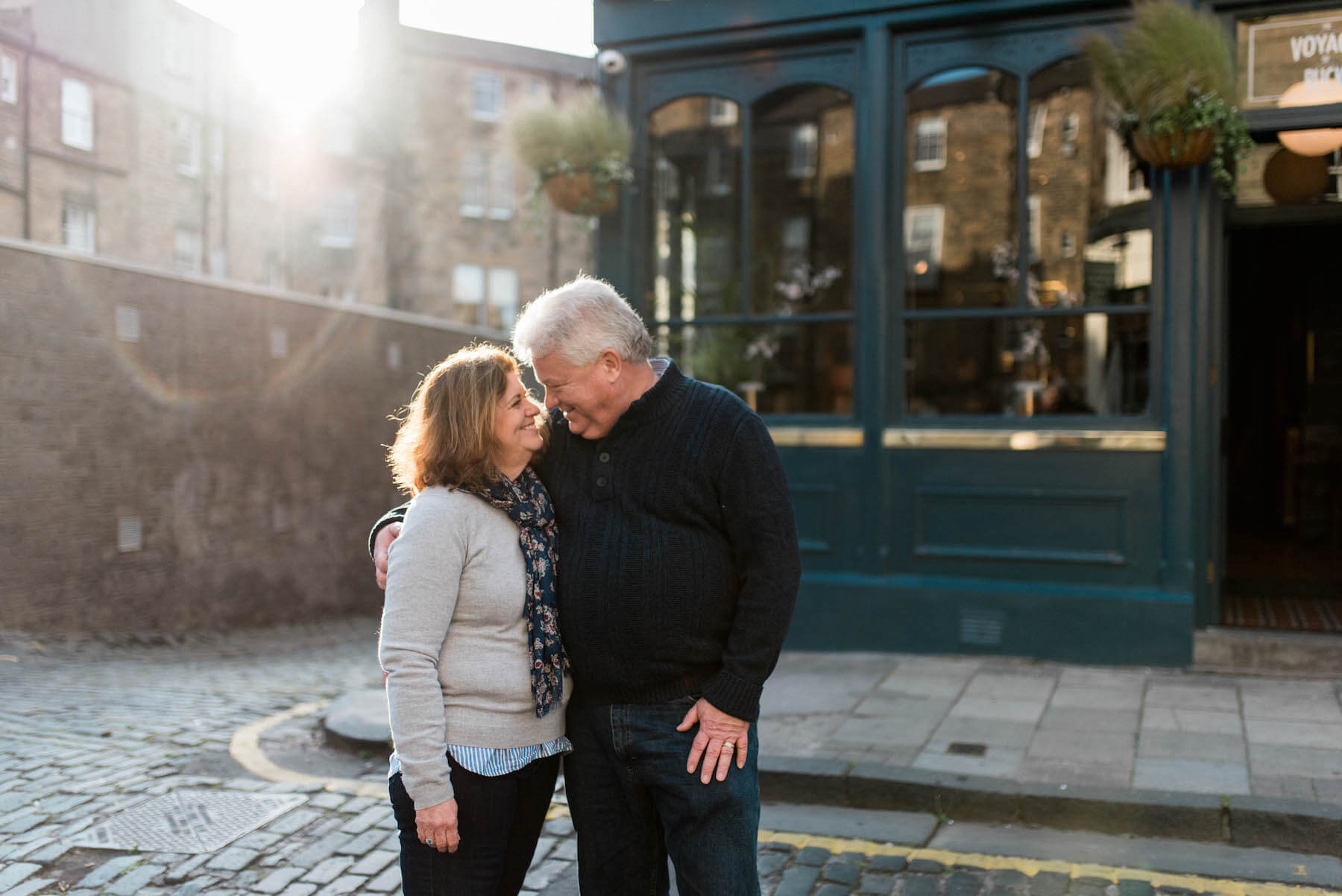 couple holding each other in front of a pub in Edinburgh, Scotland