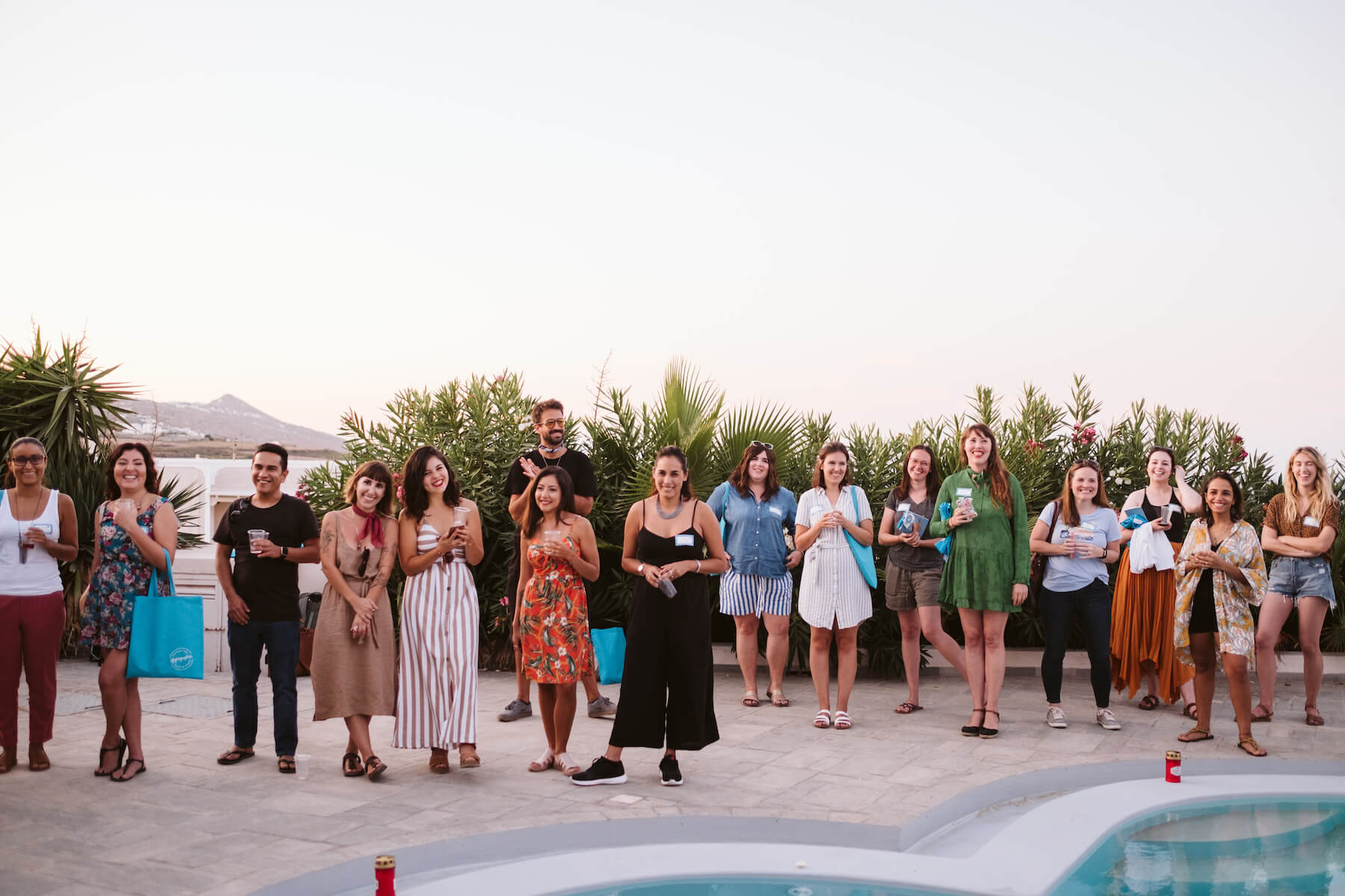 People laughing and talking around a pool in Santorini, Greece