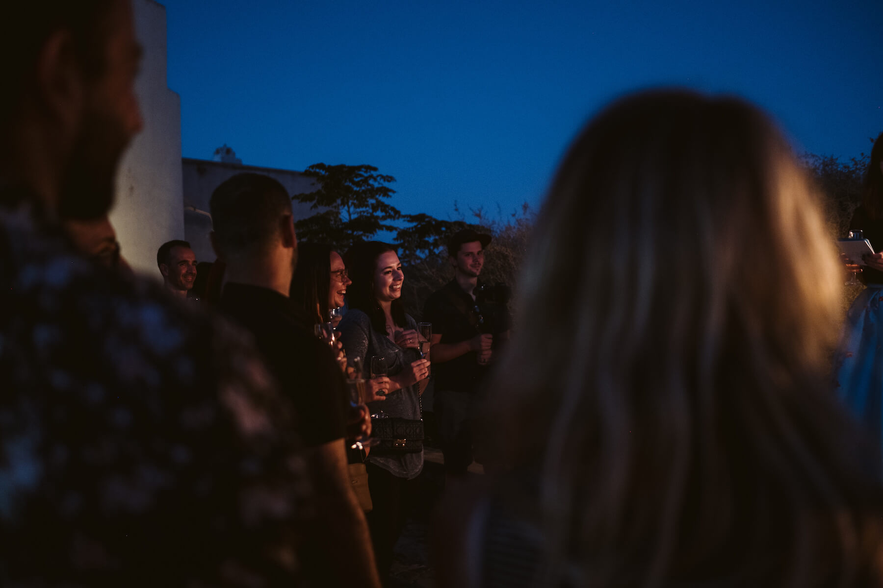 Women laughing while listening to a speech in Santorini, Greece