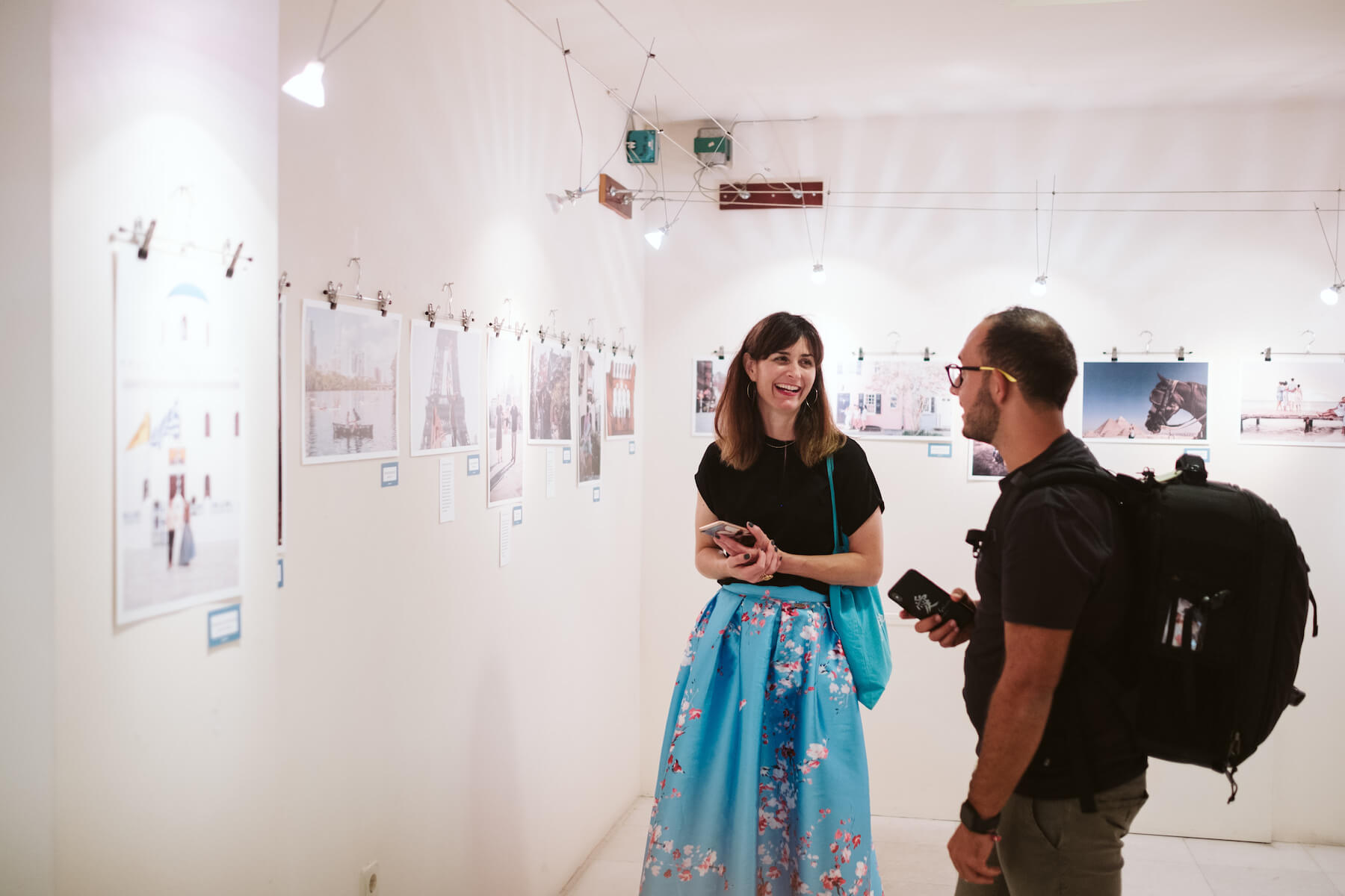 Two people laughing in an art gallery in Santorini, Greece