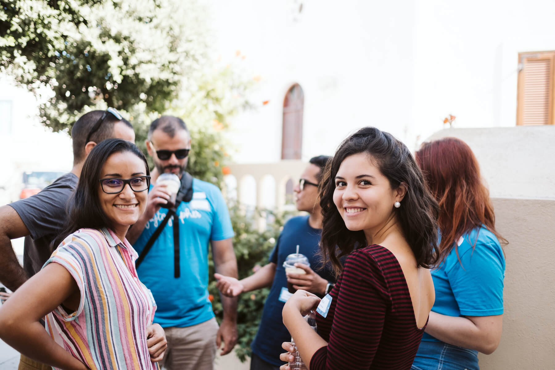 Two women smiling together in a group in Santorini, Greece