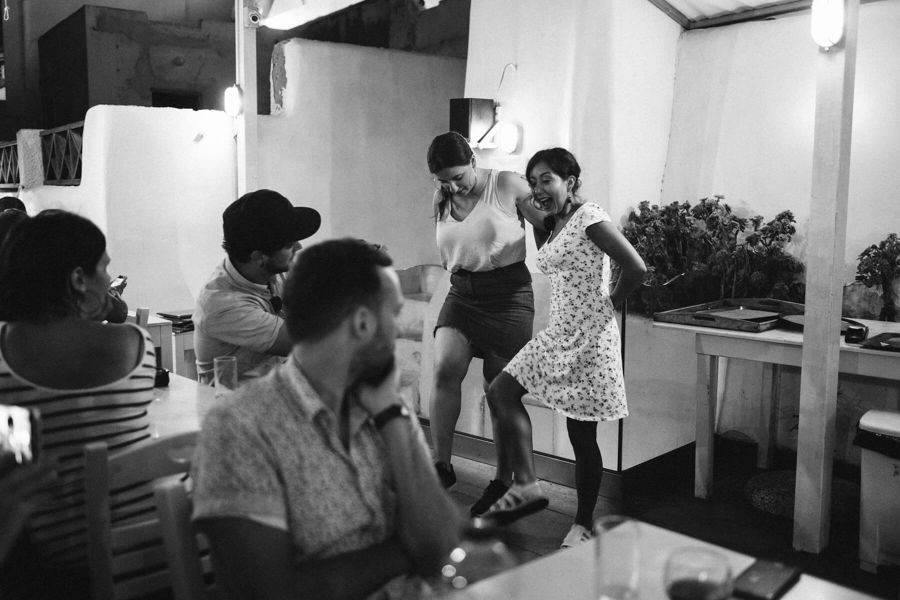 Two women dancing at a restaurant in Santorini, Greece