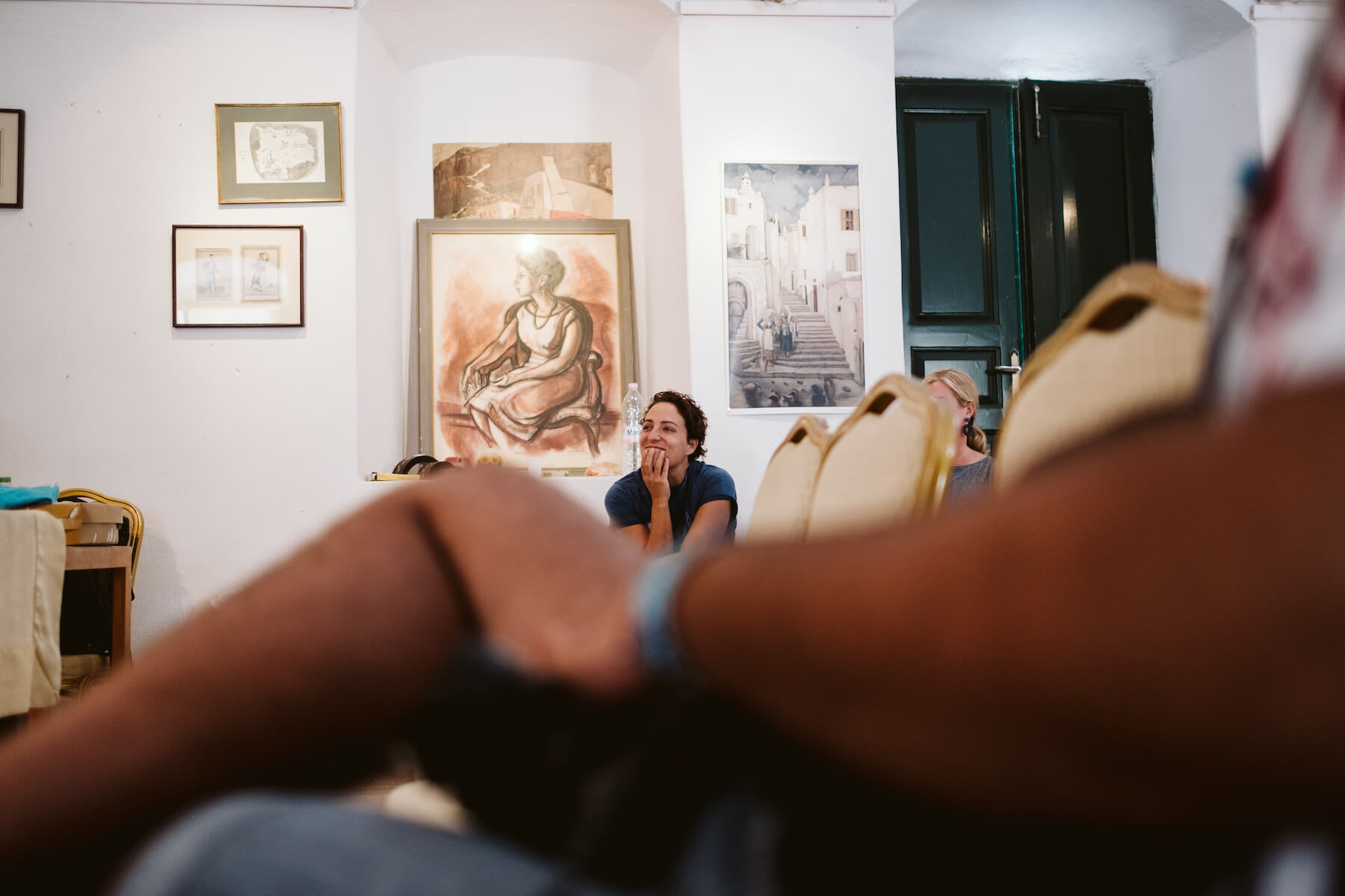 woman smiling while listening to speech in a conference room in Santorini, Greece