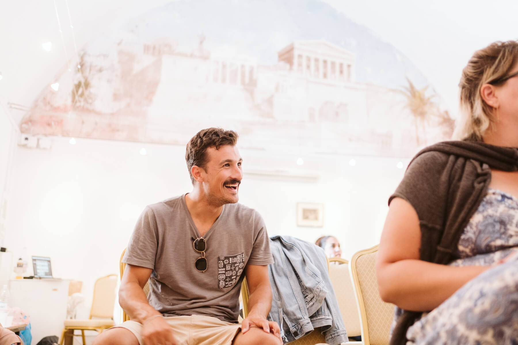Man laughing while seated in a conference room in Santorini, Greece