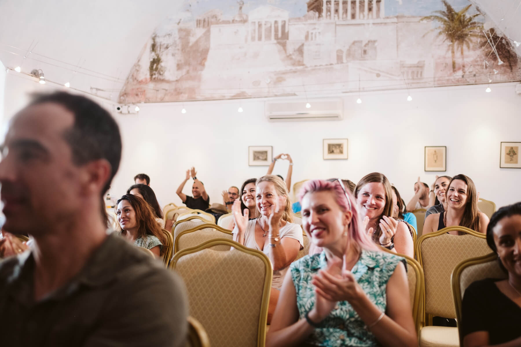 People applauding in a conference room in Santorini, Greece