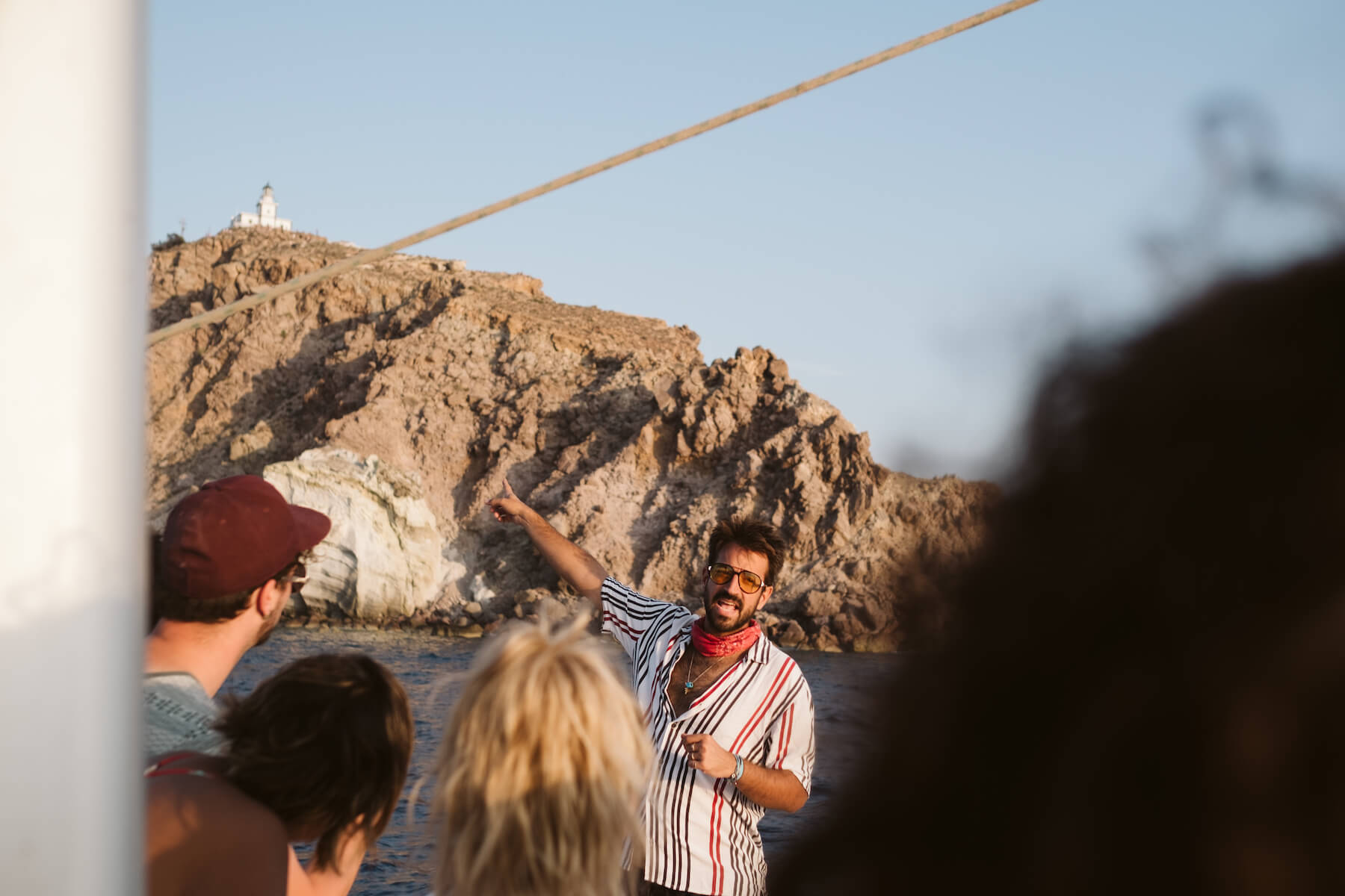 A man talking to a group on a boat in Santorini, Greece