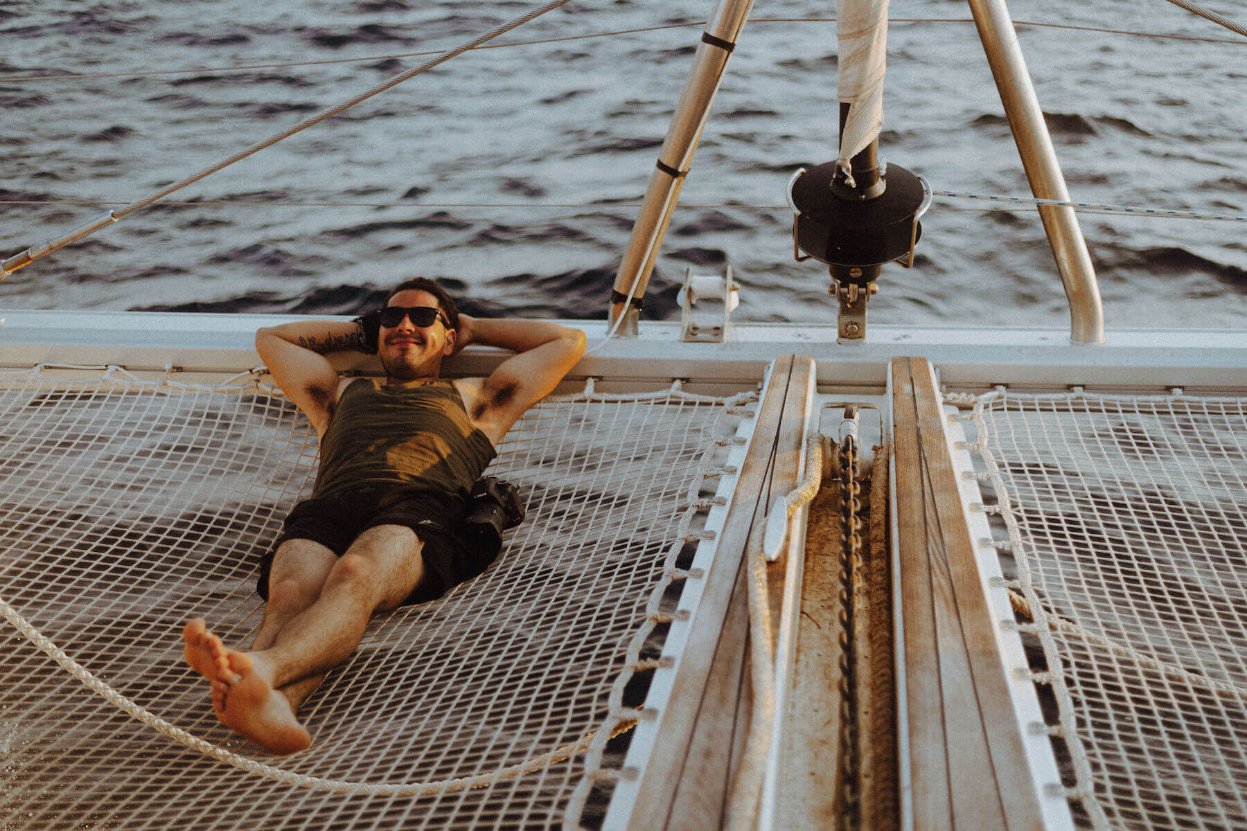 Man smiling and lounging on a boat in Santorini, Greece