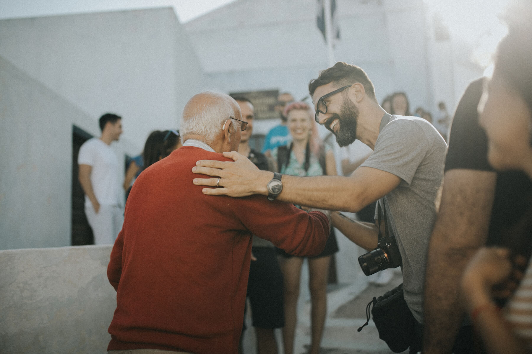 A group of photographers smiling at an elderly man in Santorini, Greece
