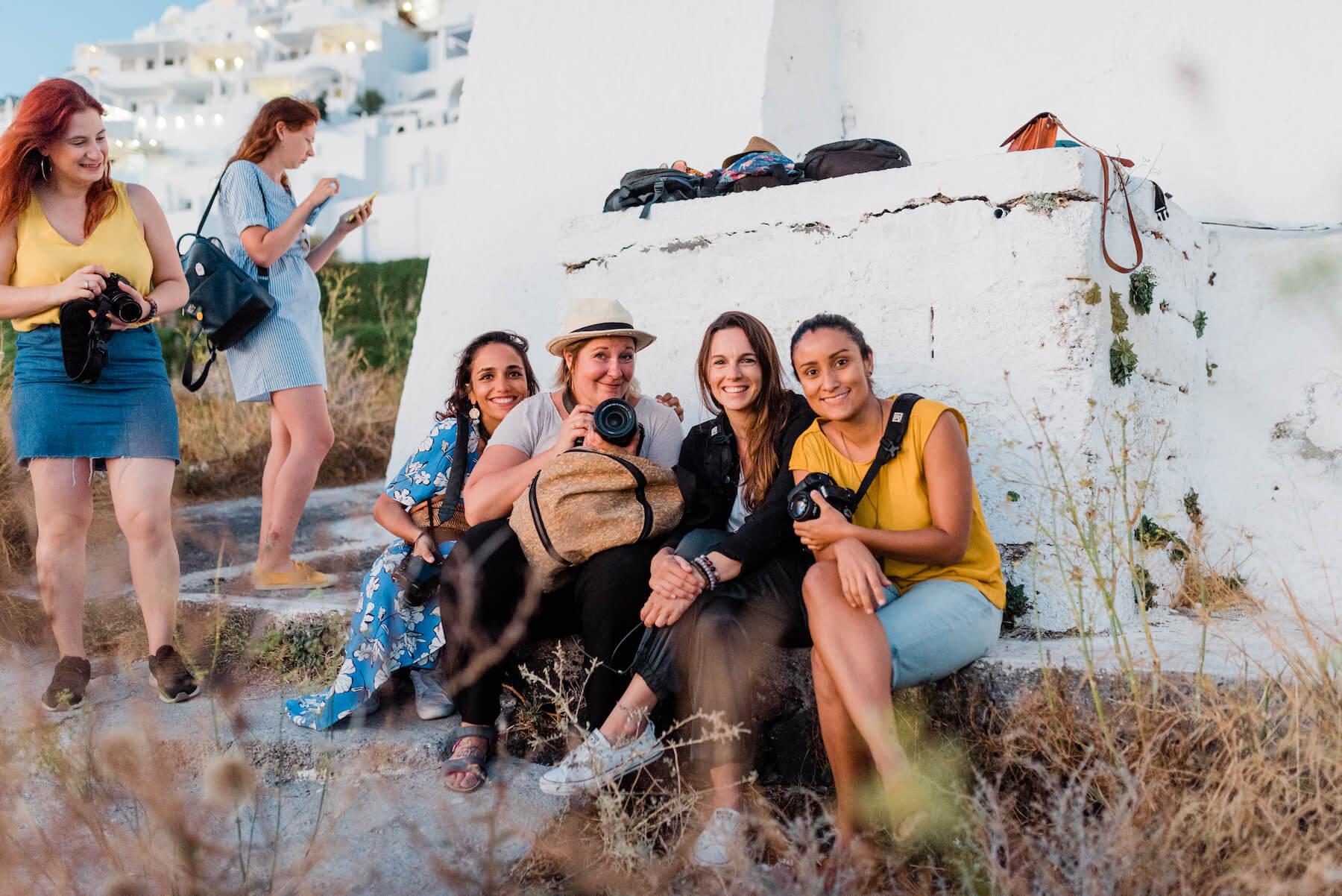 Four photographers sitting and smiling together in Santorini, Greece