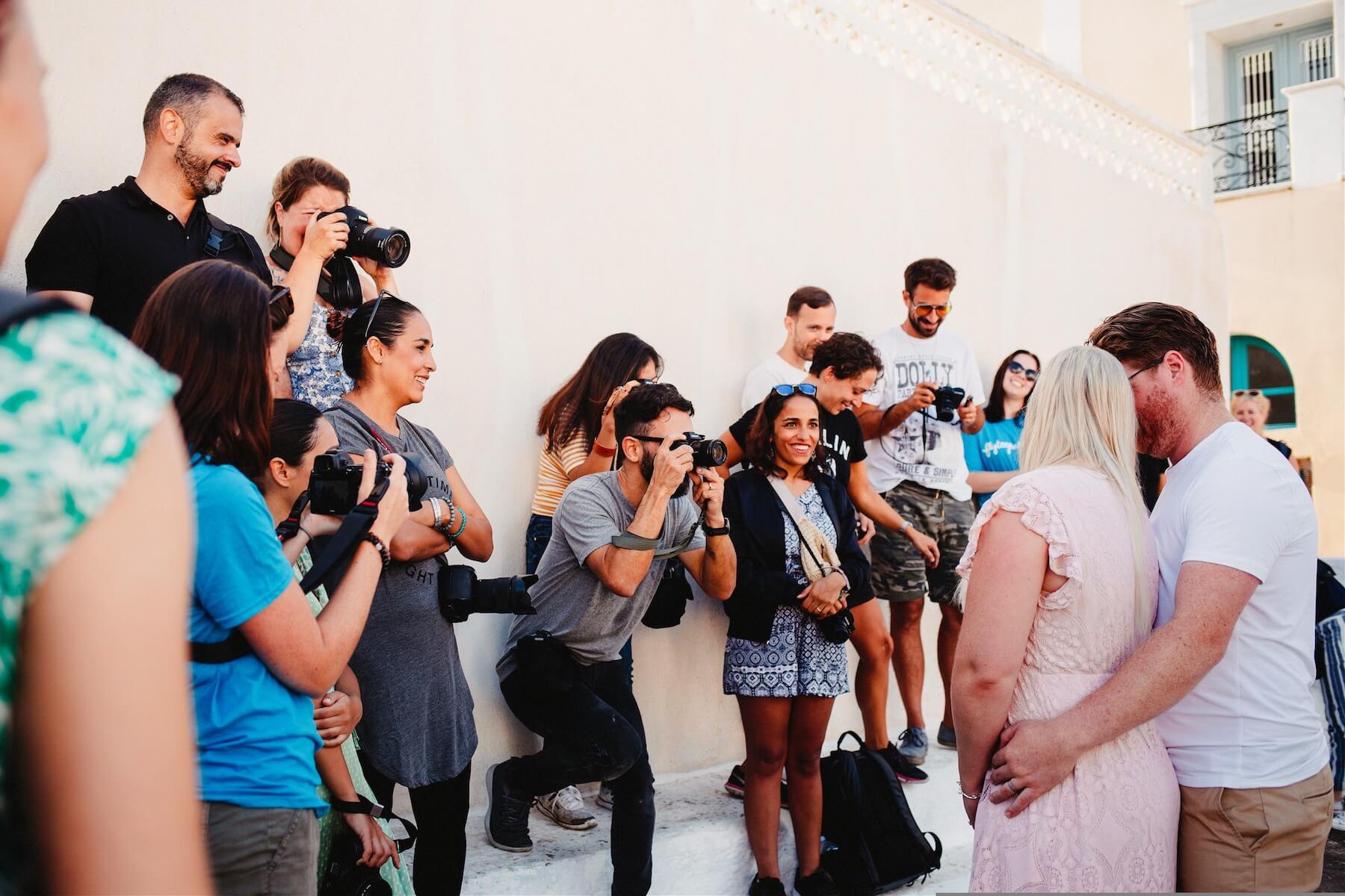 Photographer shooting a couple in front of church in Santorini, Greece
