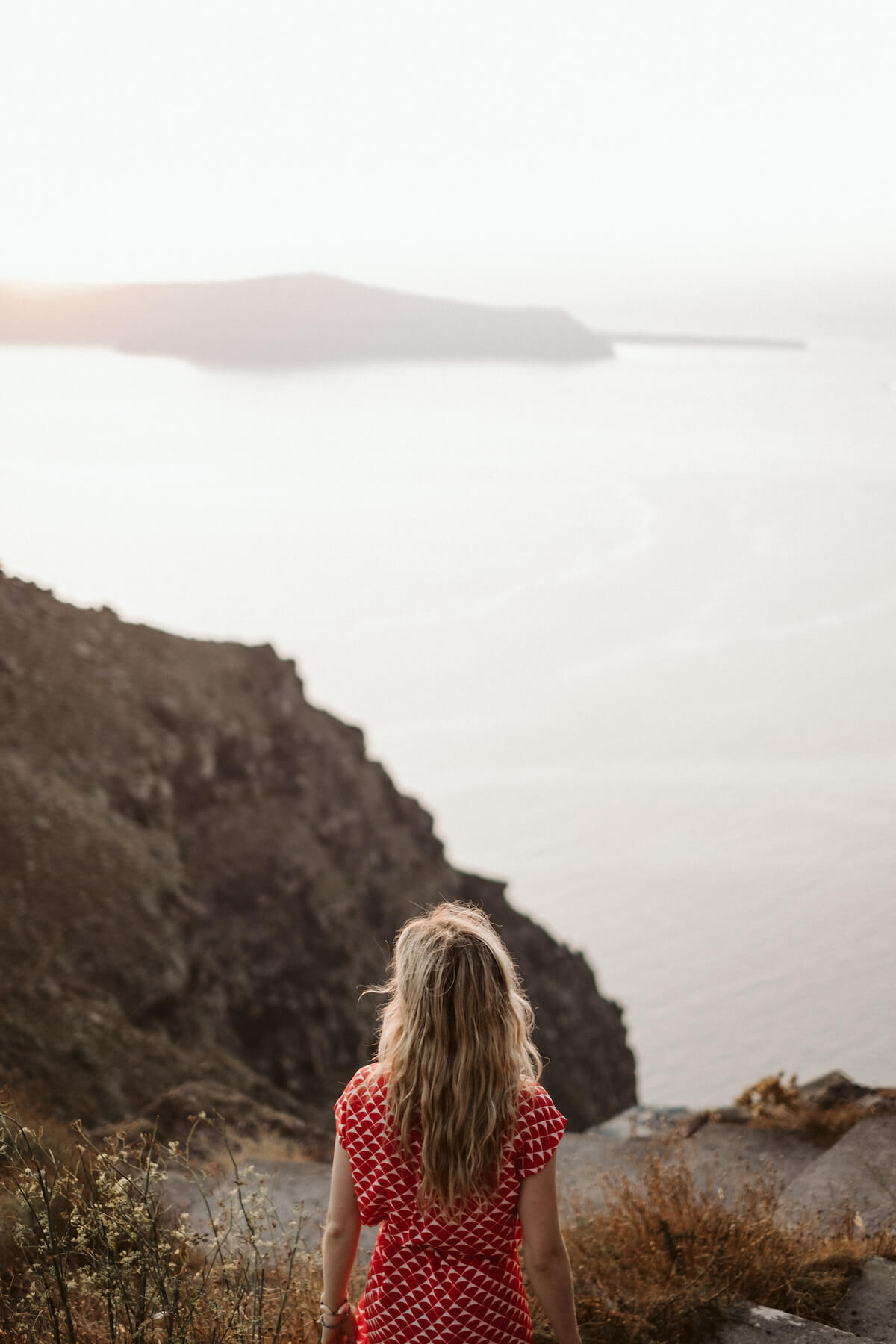 Woman looking at the sunset in Santorini, Greece