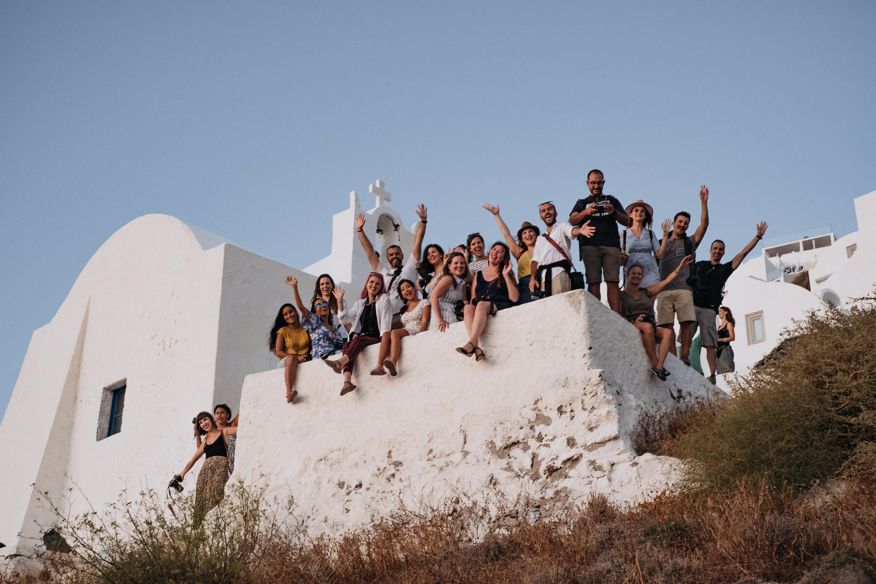 Photographers smiling and waving in a group in Santorini, Greece