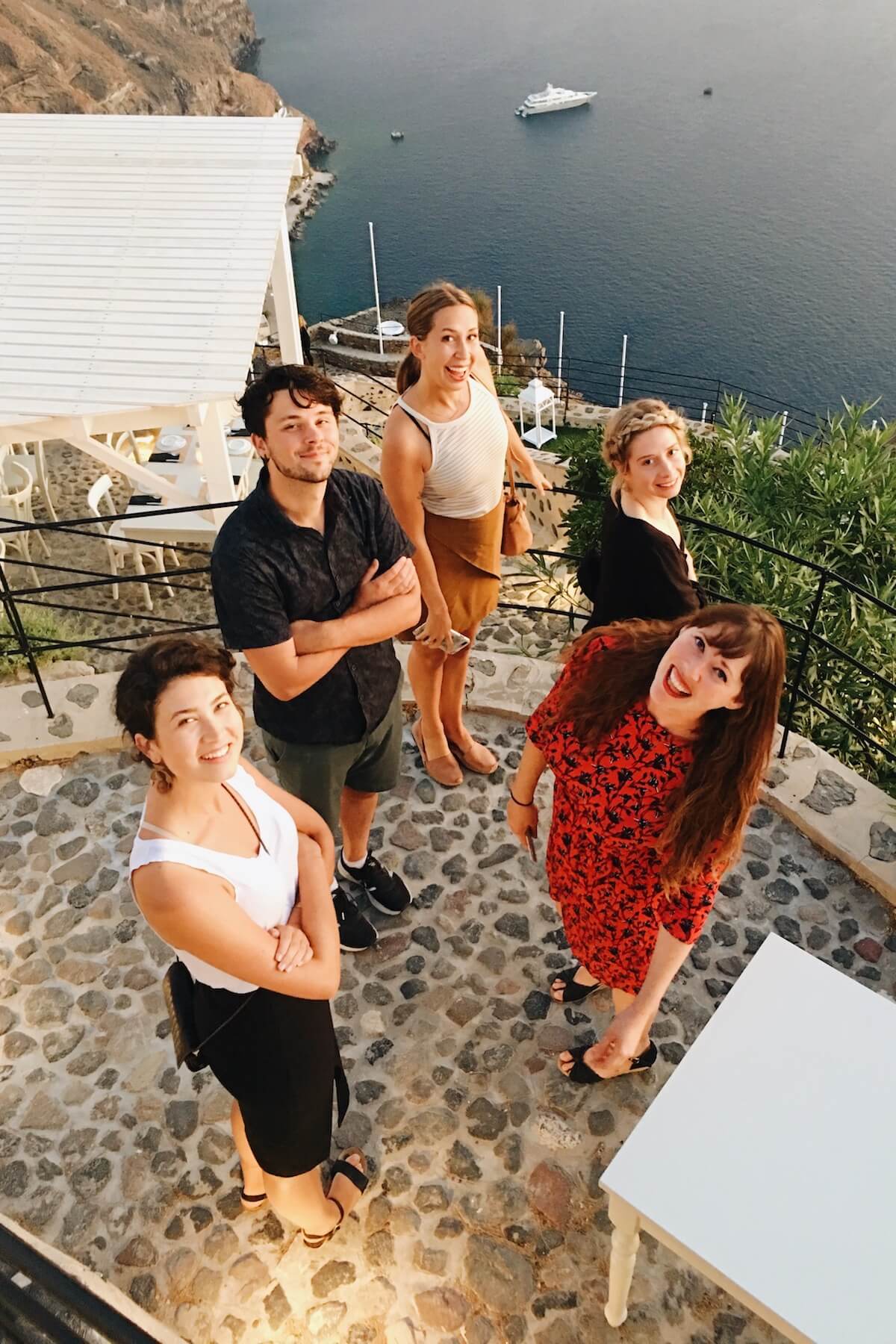 Group of people looking up and smiling in Santorini, Greece.