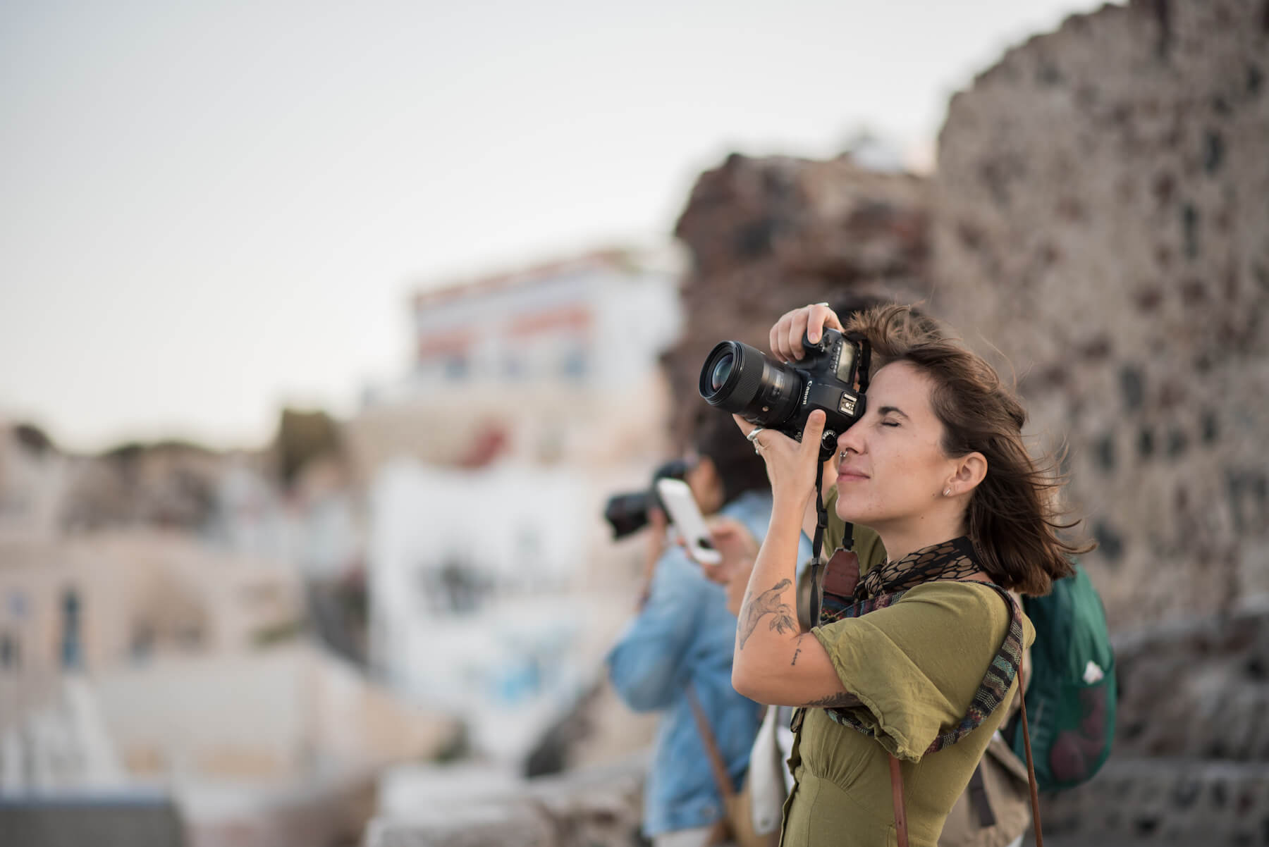A woman taking a photo in Santorini, Greece.