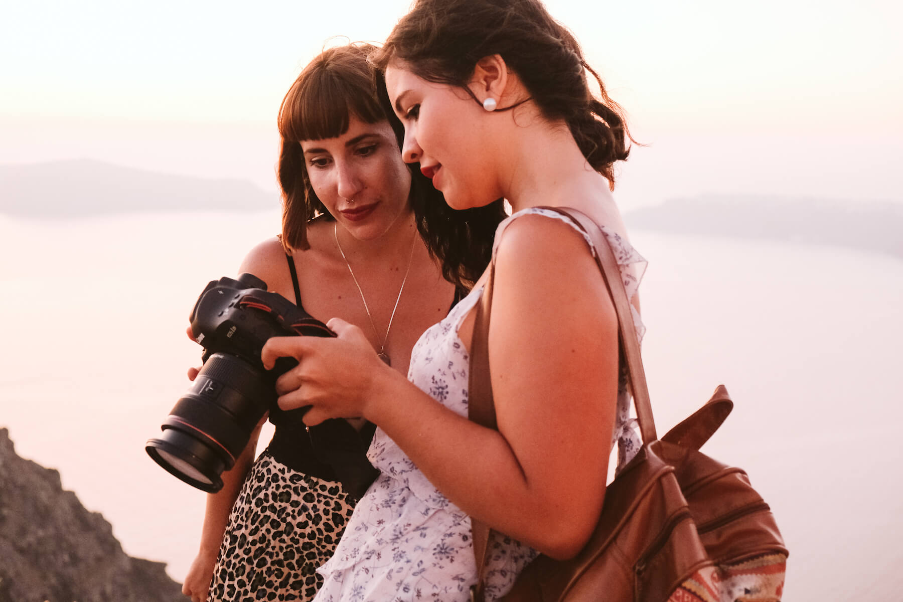 Two photographers looking at a camera screen in Santorini, Greece