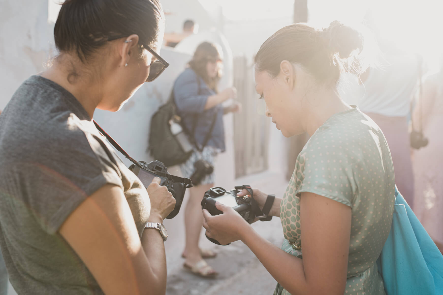 Two photographers looking at the back of a camera in Santorini, Greece