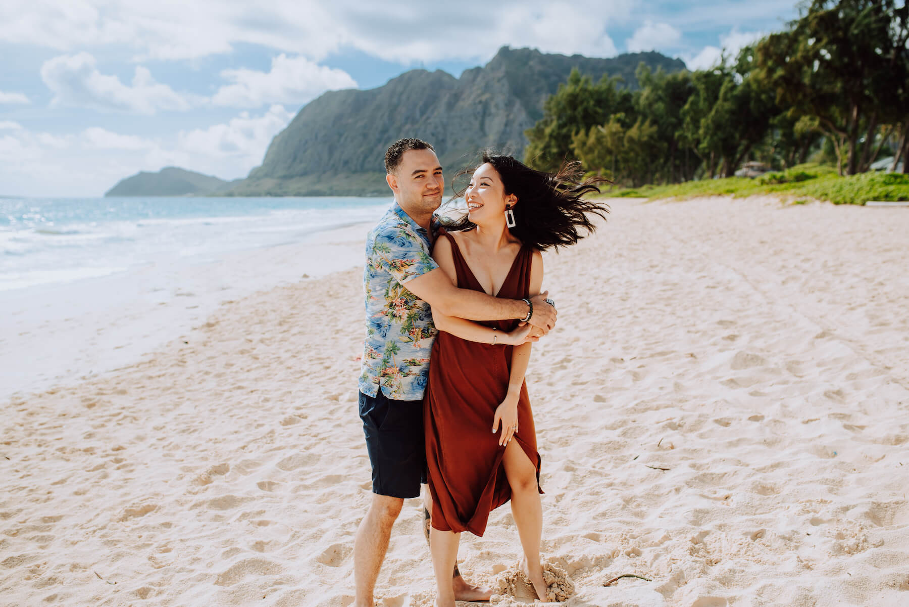 Couple embracing and being playful on the beach in Honolulu, Hawaii
