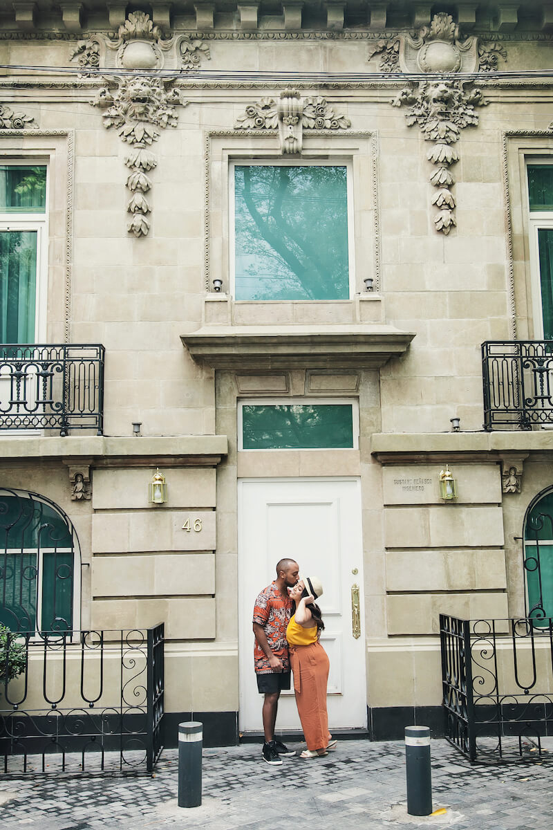 couple hugging each other in front of a large door in Mexico City, Mexico