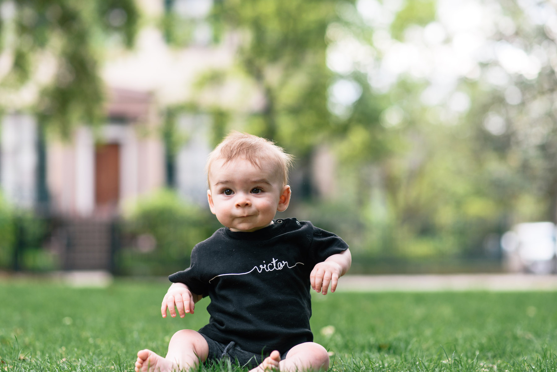 a toddler sitting on the grass in a park in Savannah, Georgia, United States of America