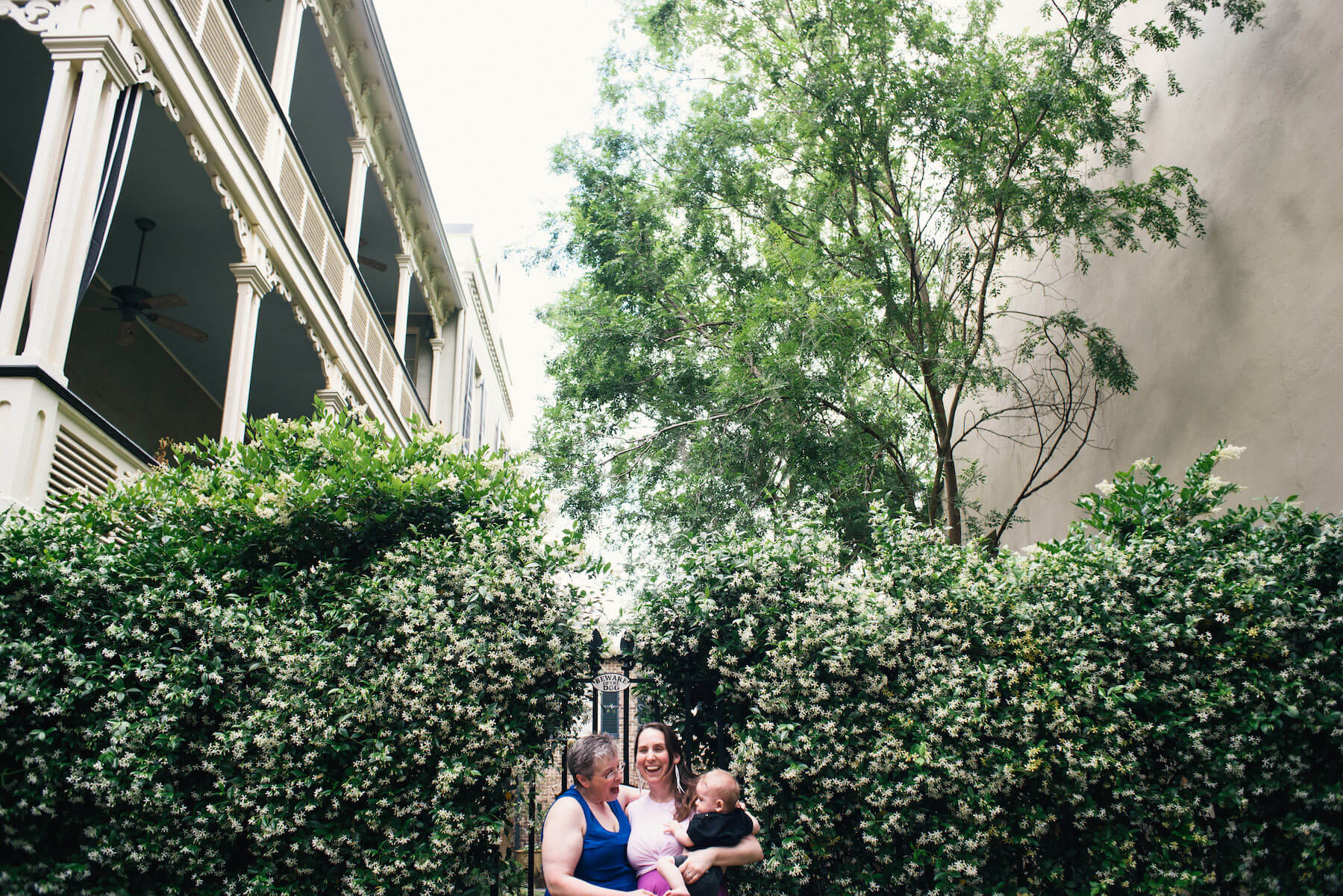 a LGBTQ Couple with their child in front of a historic building in Savannah, Georgia, United States of America