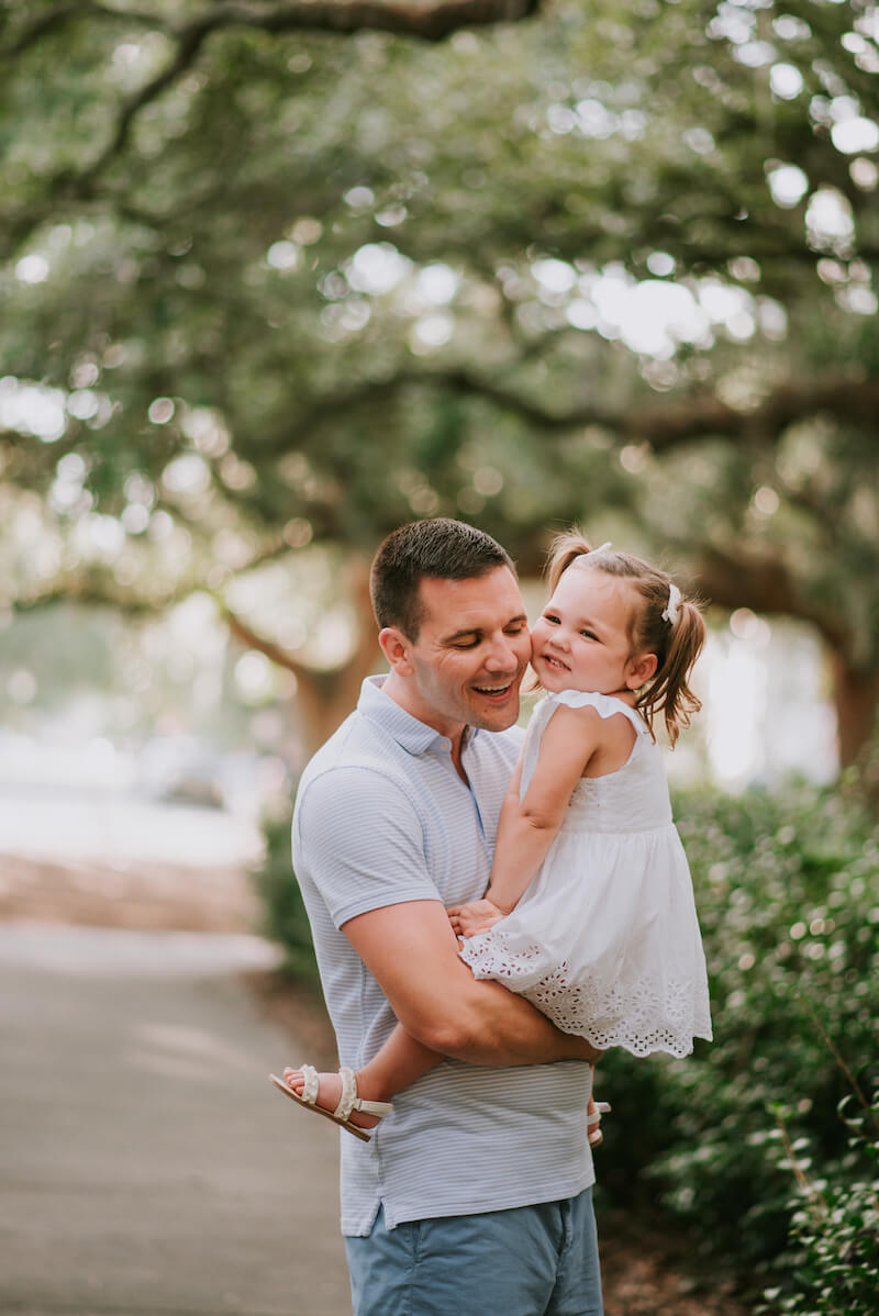 a father holding his daughter in a park in Savannah, Georgia, United States of America