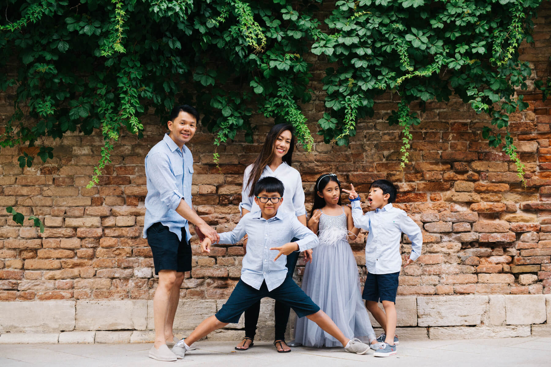 family of four standing in front of a red phone booth in London, England