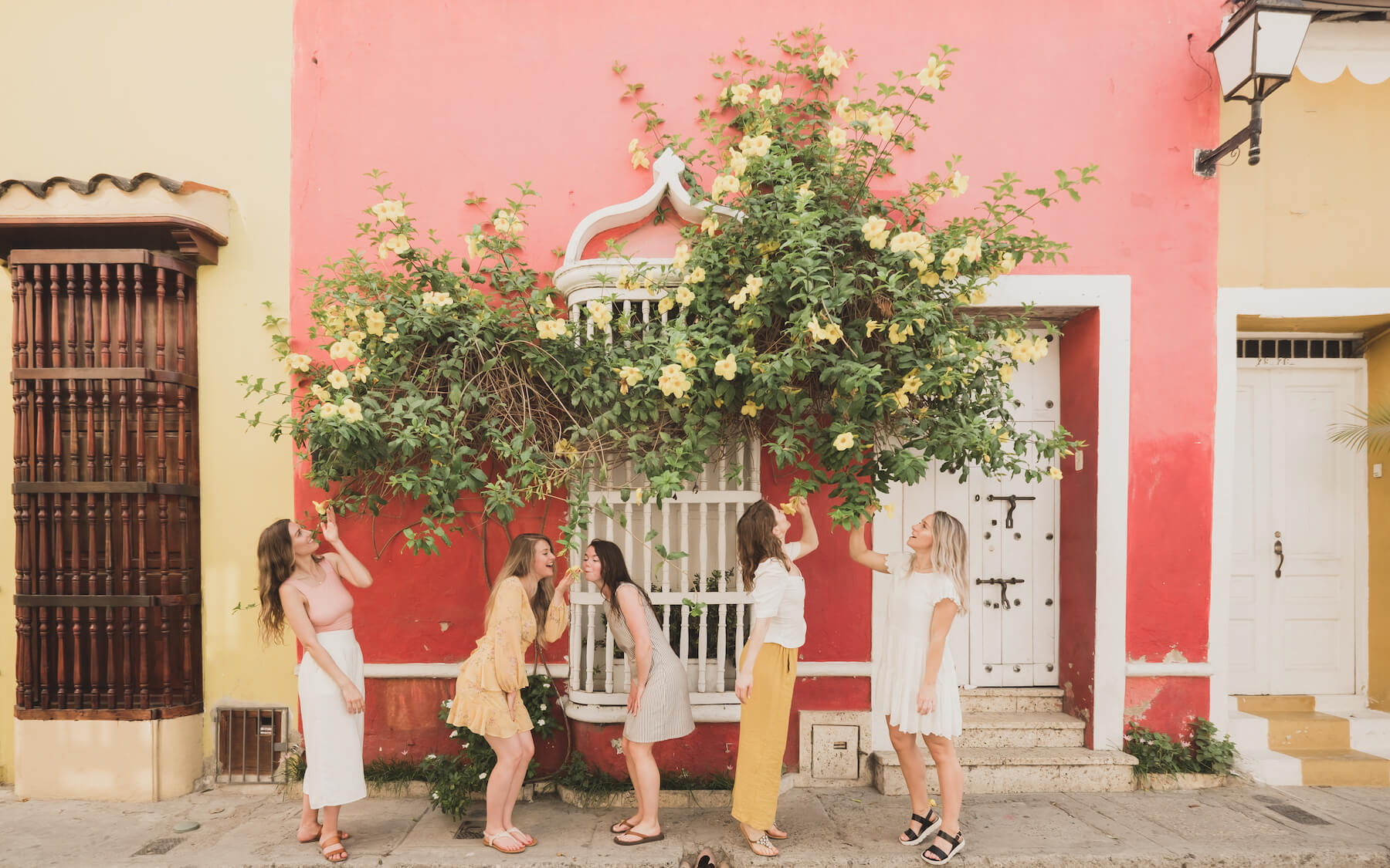 5 girlfriends having fun and smelling flowers on the streets of Cartagena, Colombia