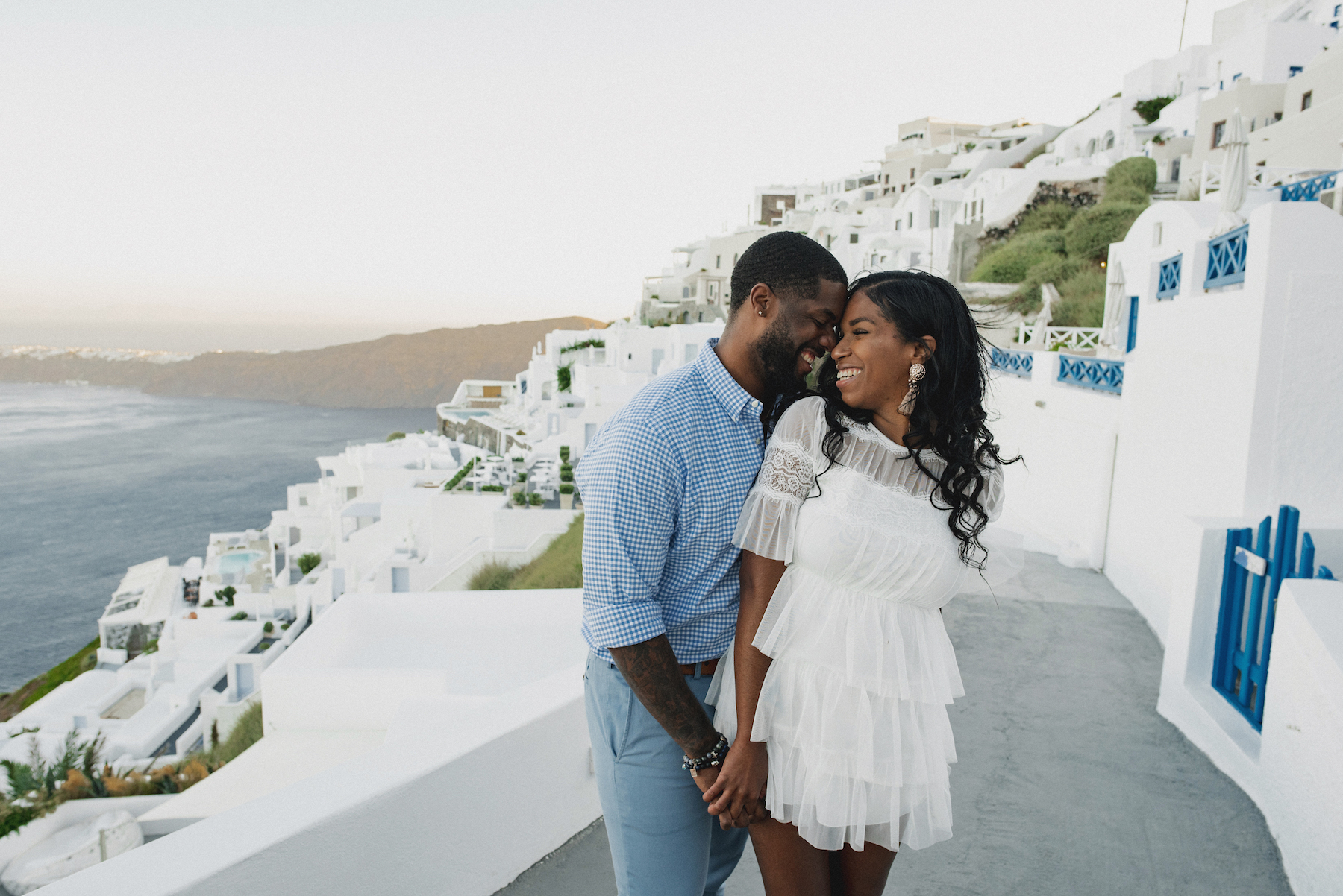 couple hugging each other under a palm tree in Maui, Hawaii