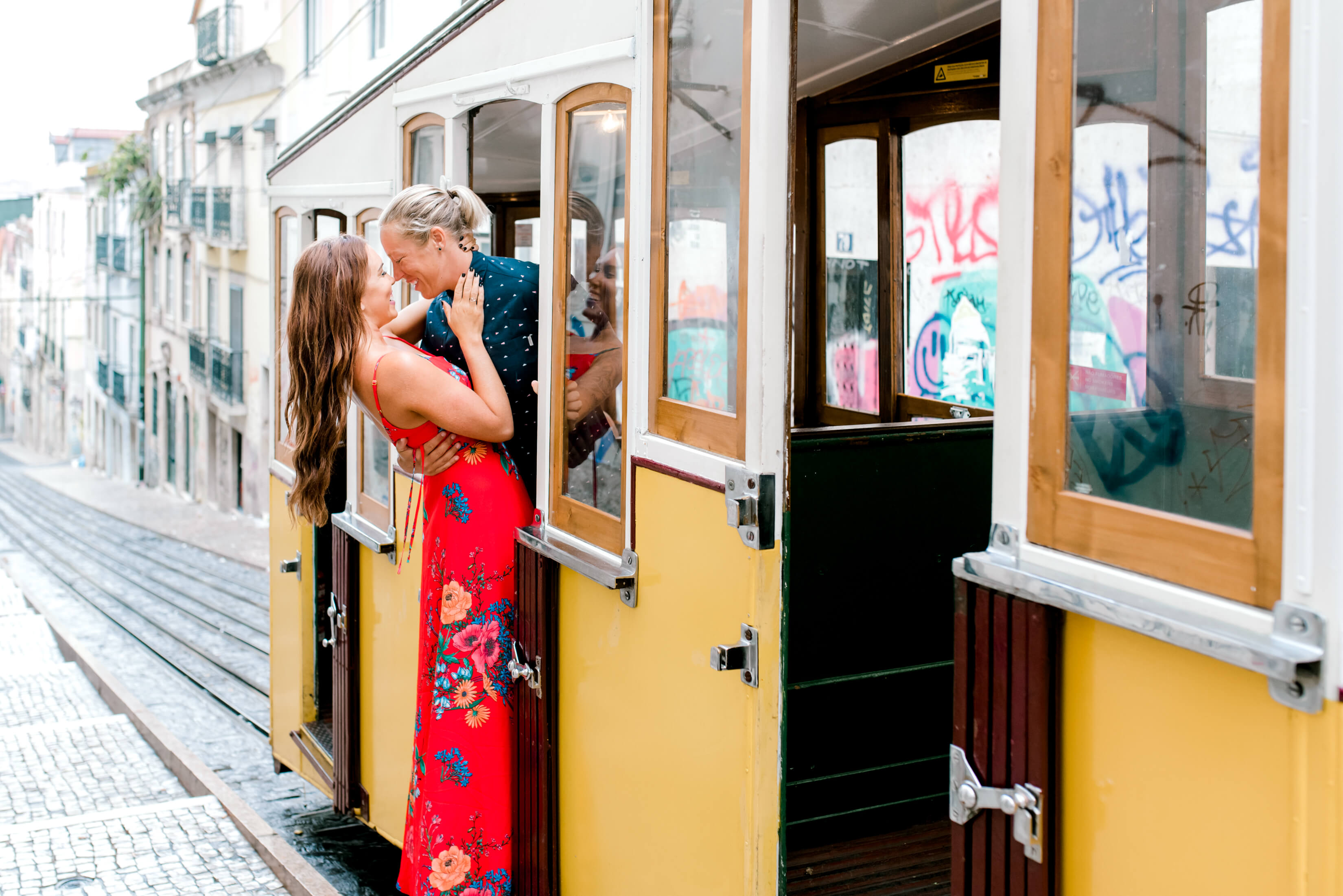 LGBTQ couple holding each other on a tram in Lisbon, Portugal
