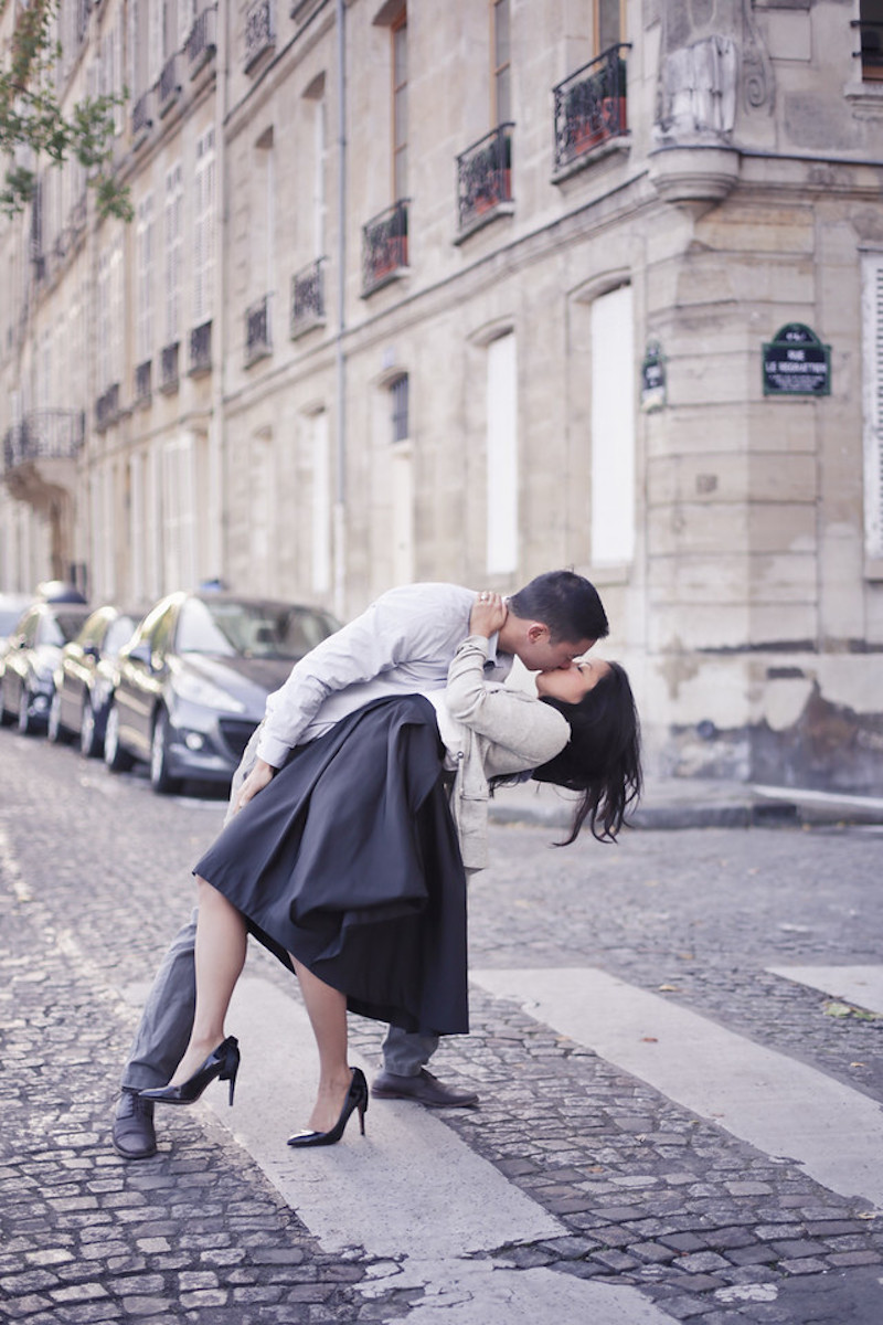 a man is kissing a woman on the streets of Paris, France