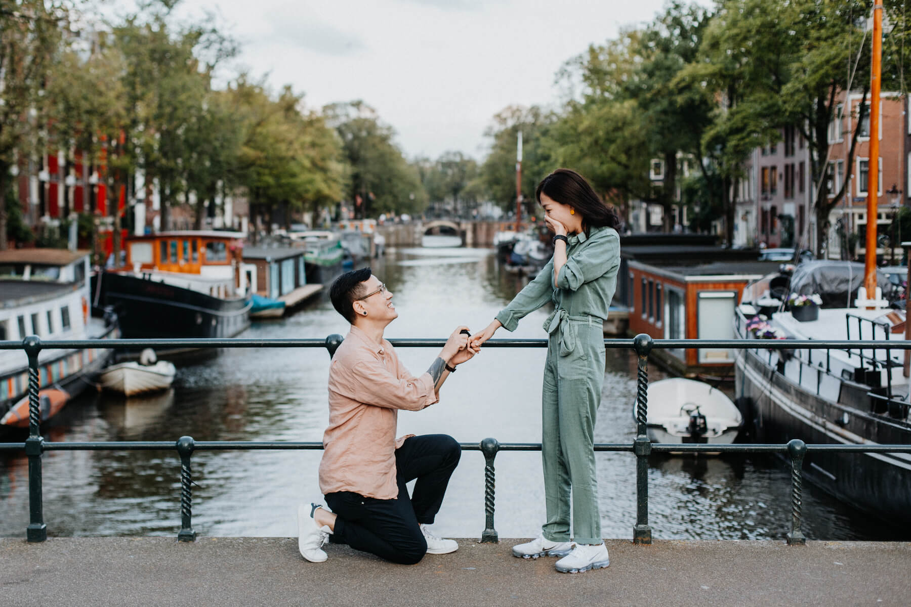 the man is on his knee and proposing to the woman in Amsterdam, Netherlands