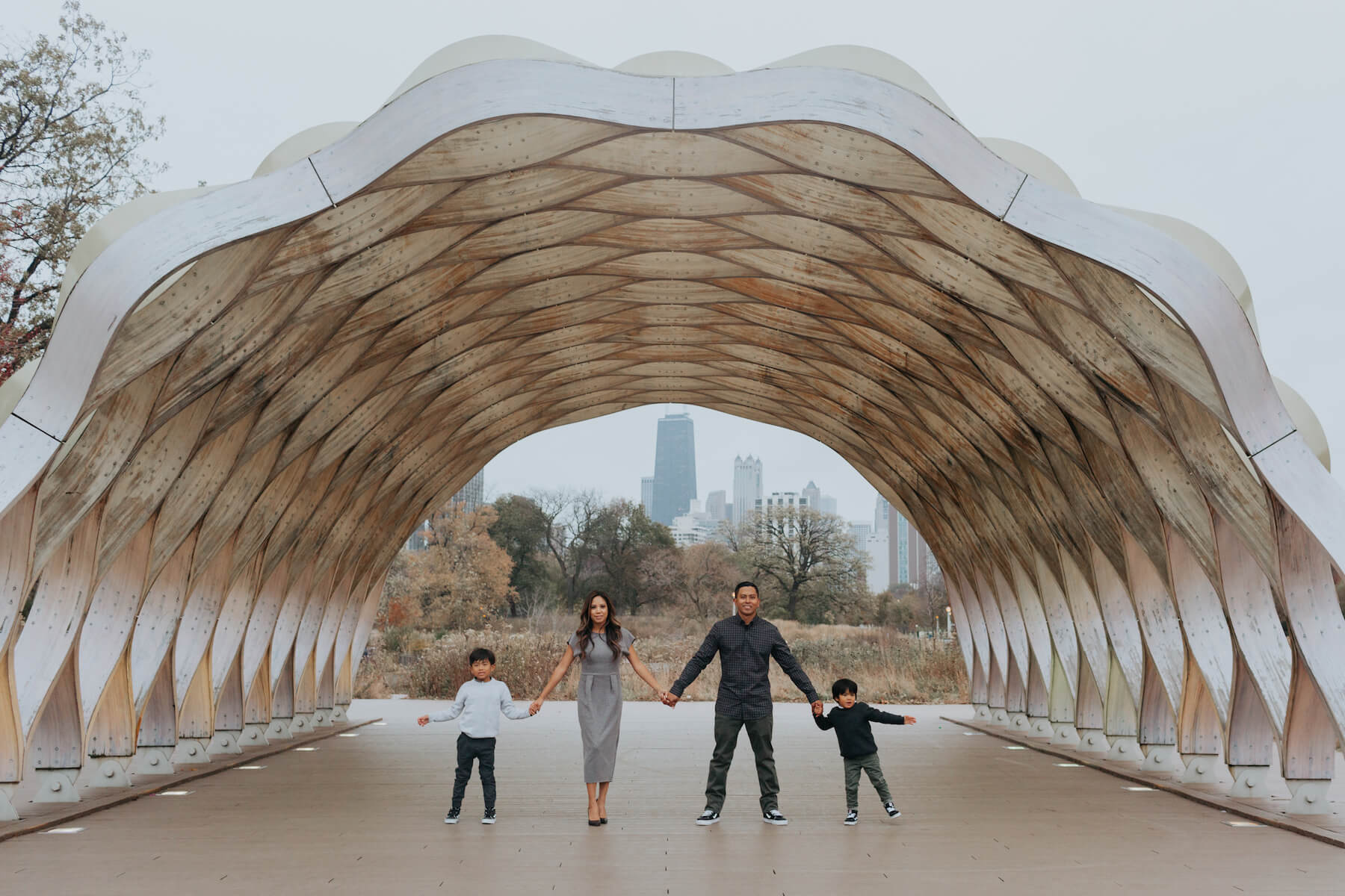 family of four holding hands under a structure in Chicago, Illinois, United States of America