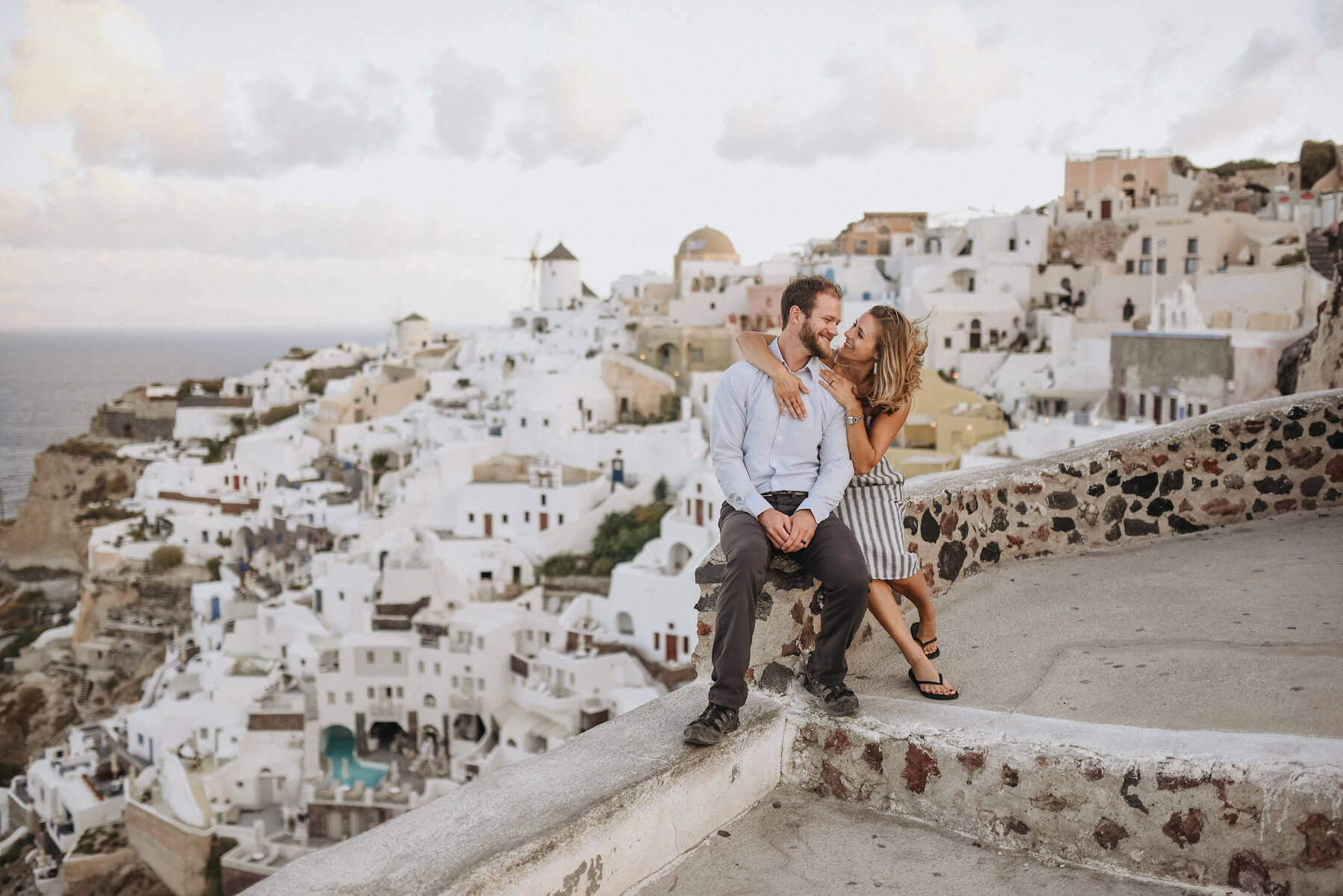 couple sitting and looking at each other in Santorini, Greece