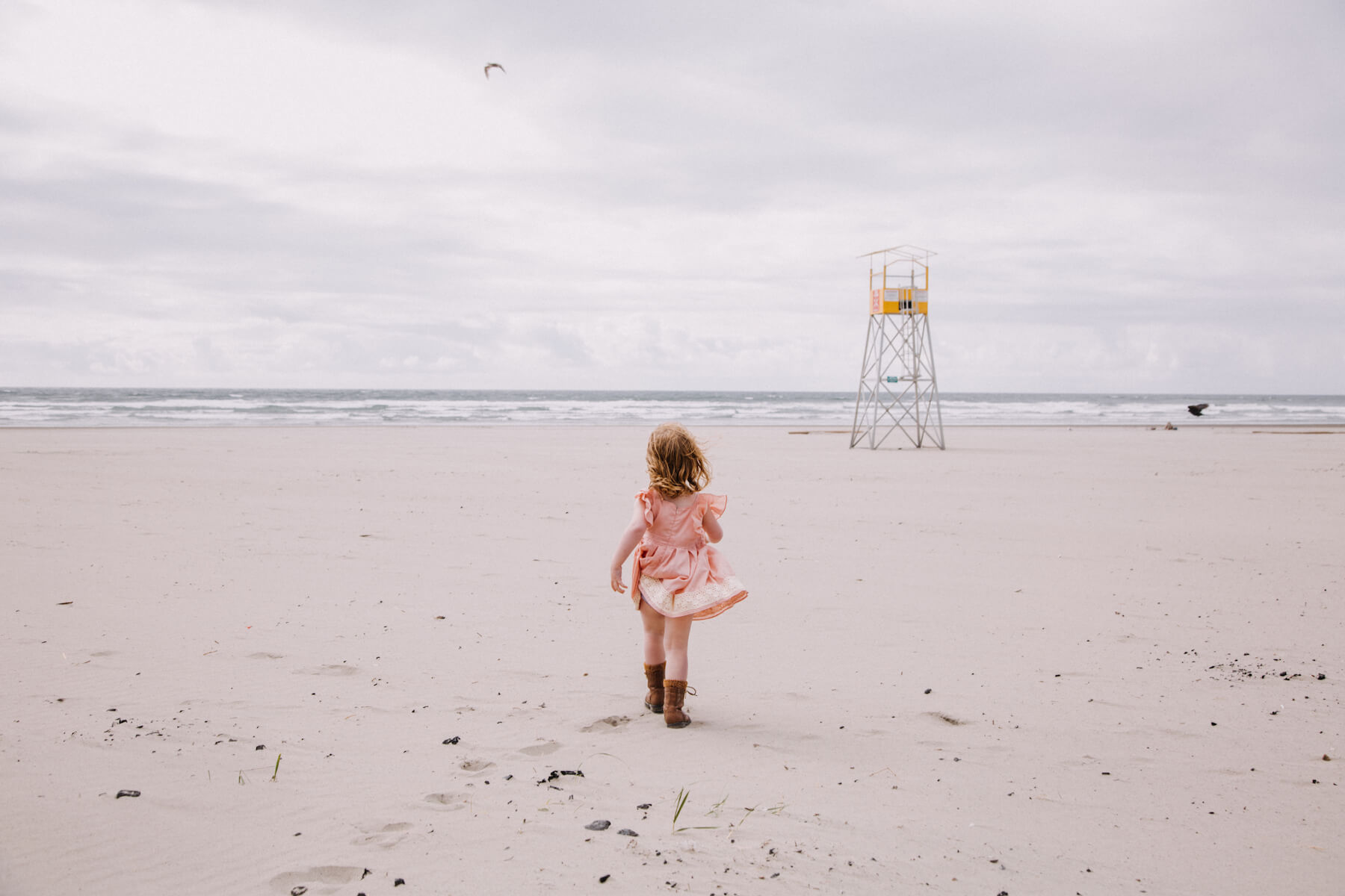small girl walking on the beach towards the ocean in Portland, Oregon