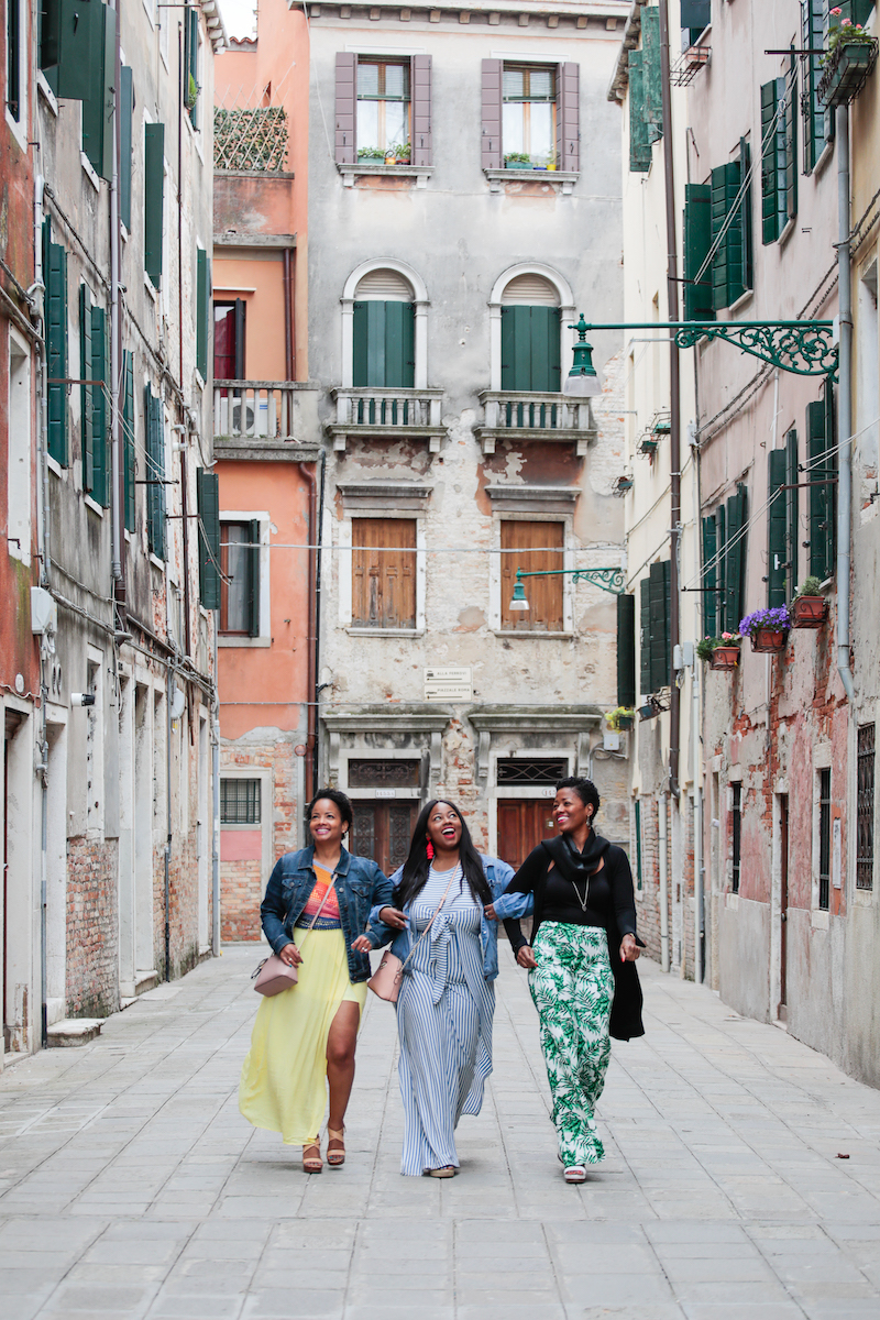 3 sisters walking through narrow streets near the canal in Venice, Italy