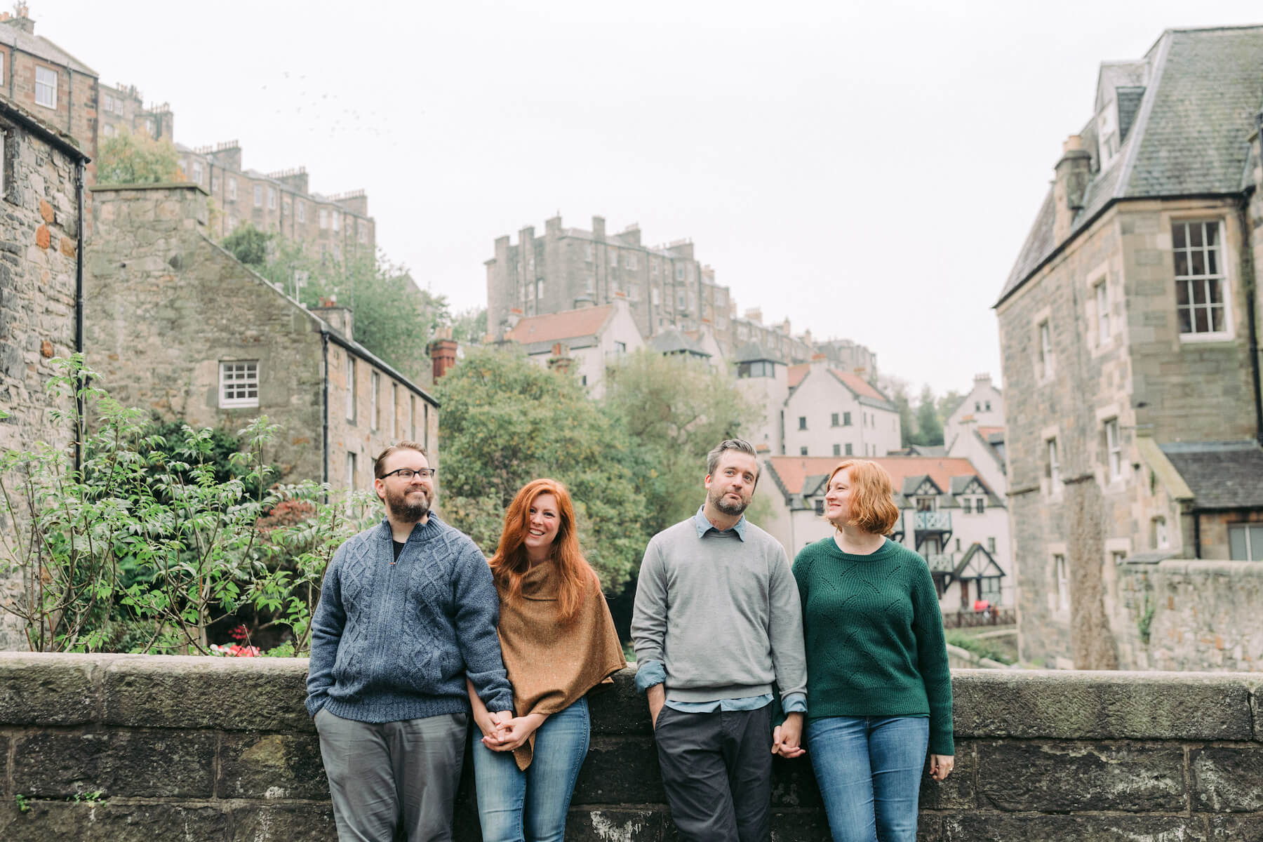 2 couples sitting on stone wall in the town of Edinburgh, UK