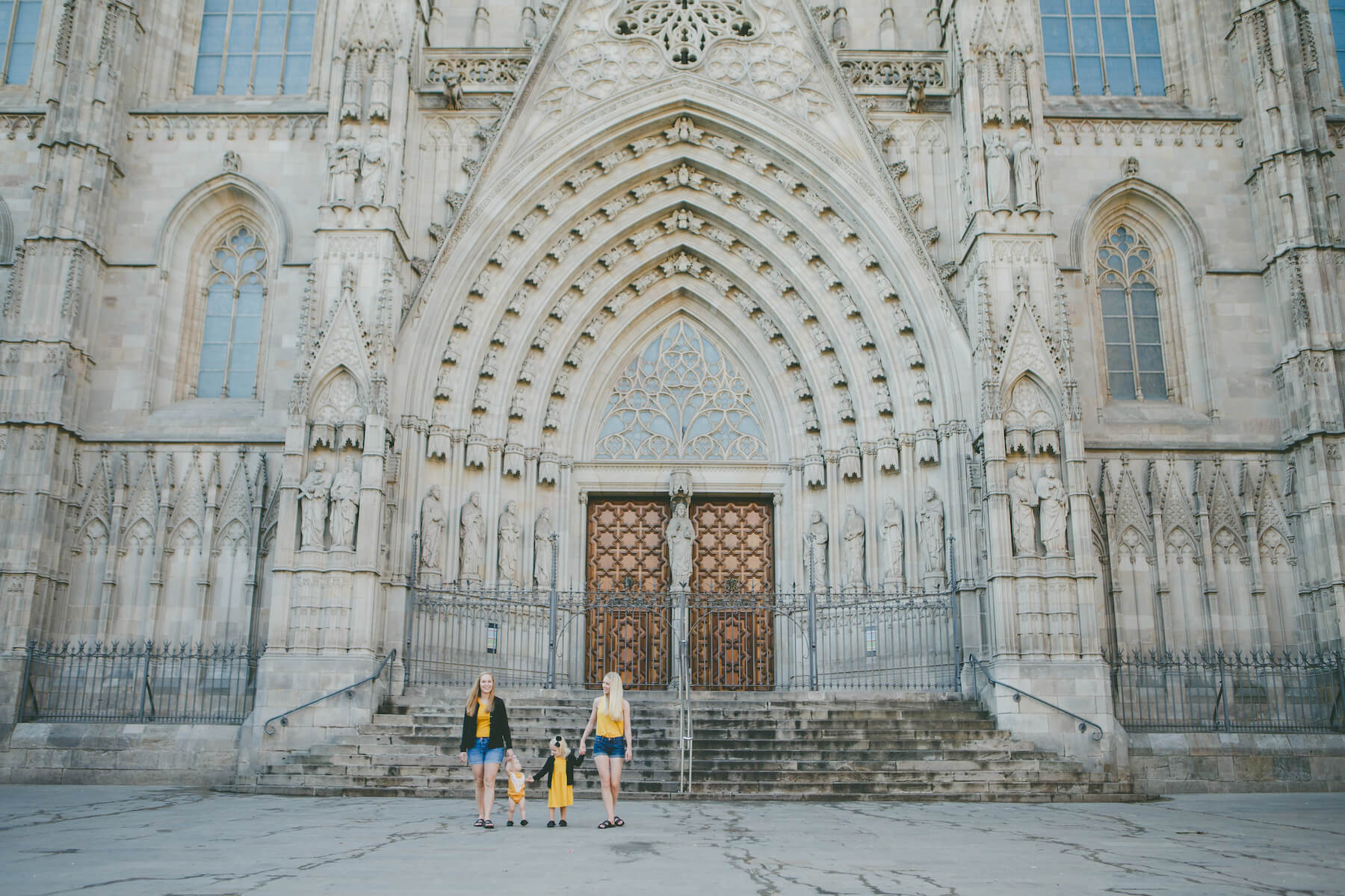 LGBTQ family of four standing in front of a church in Barcelona, Spain