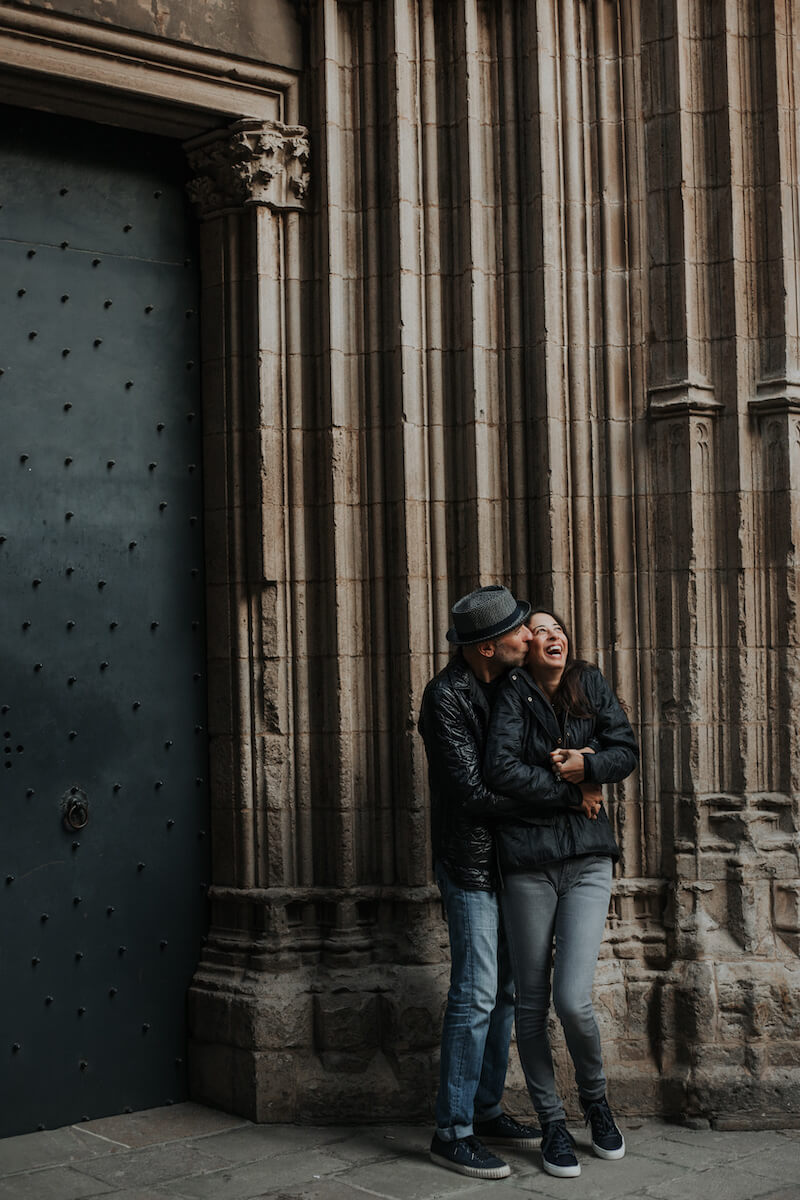 couple hugging each other and standing in front of church door in Barcelona, Spain