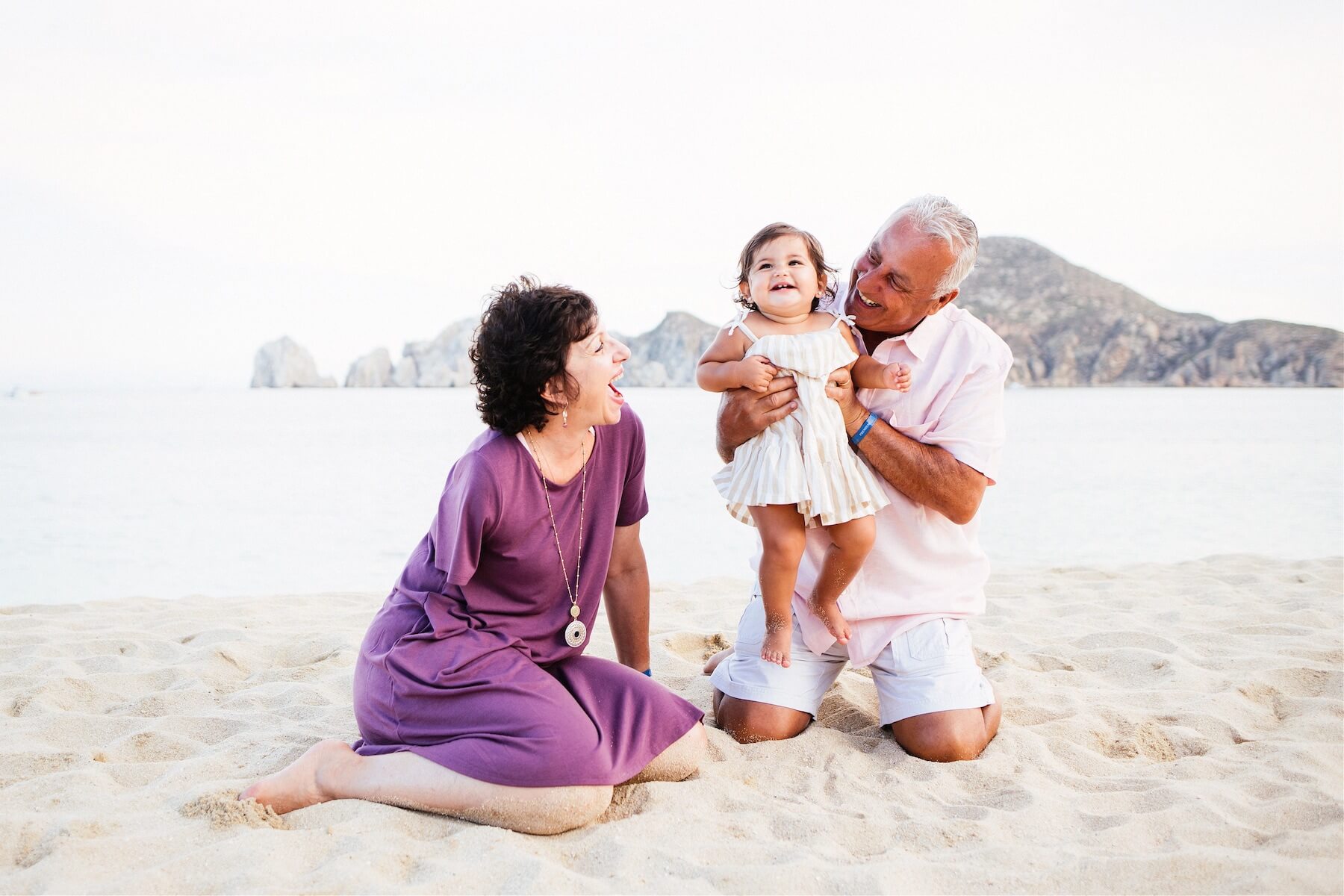 grandparents with young child on the beach in Cabo San Lucas, Mexico